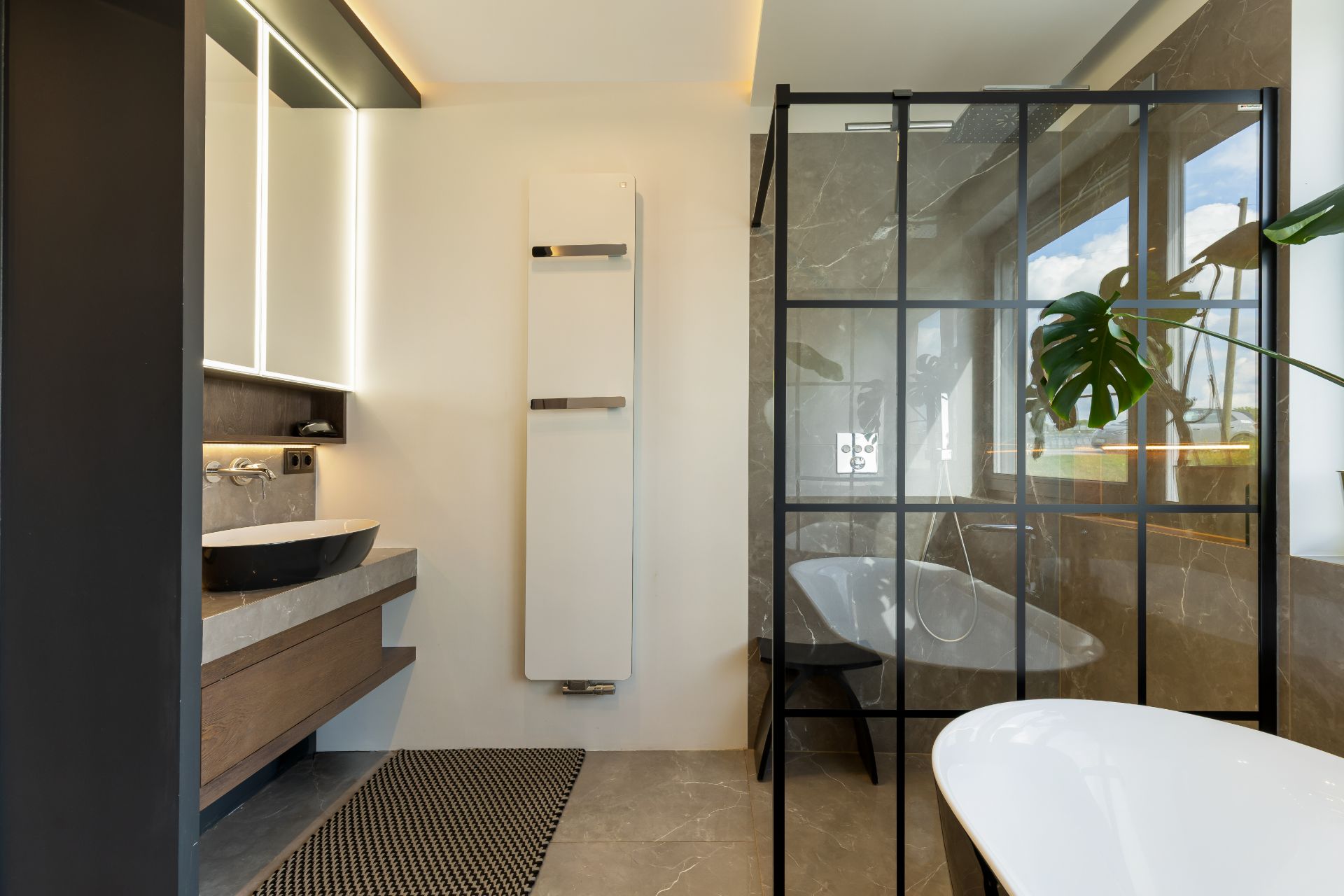Modernes Badezimmer mit großer Dusche, Spiegelwand, Waschtisch, Fenster und freistehender Badewanne.