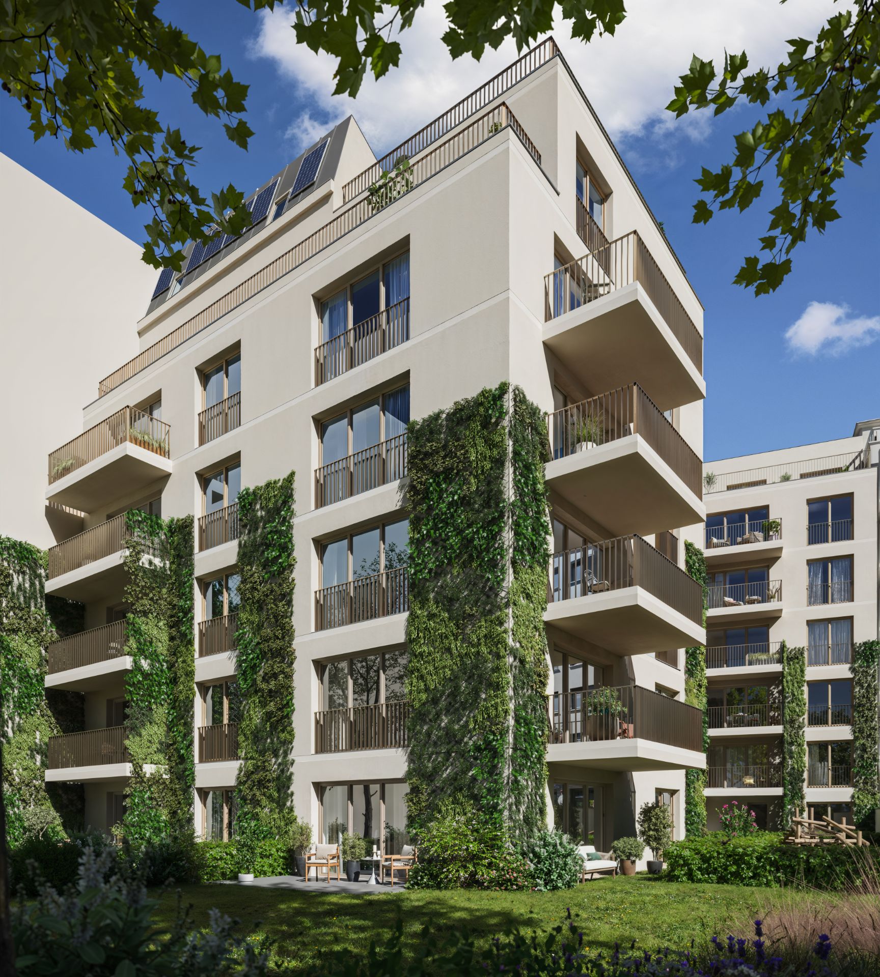 Modernes Wohngebäude mit Balkonen und begrünten Fassaden, davor ein grüner Garten.