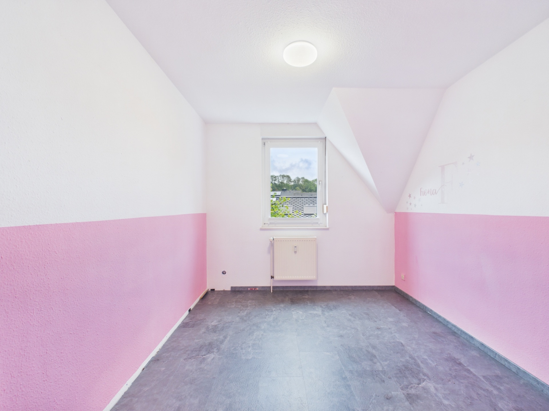 Leeres Zimmer mit pink-weißen Wänden, Fenster und dunklem Boden.