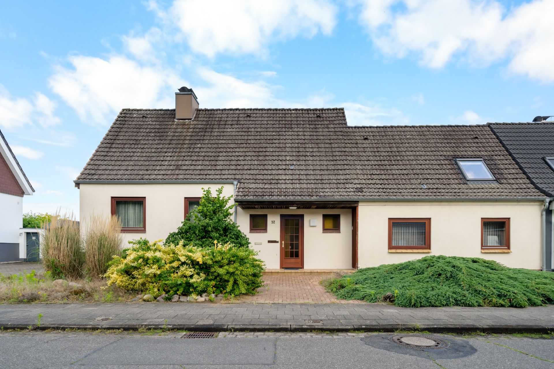 Einfamilienhaus mit Satteldach, Vorgarten und mehreren Fenstern an der Vorderseite.
