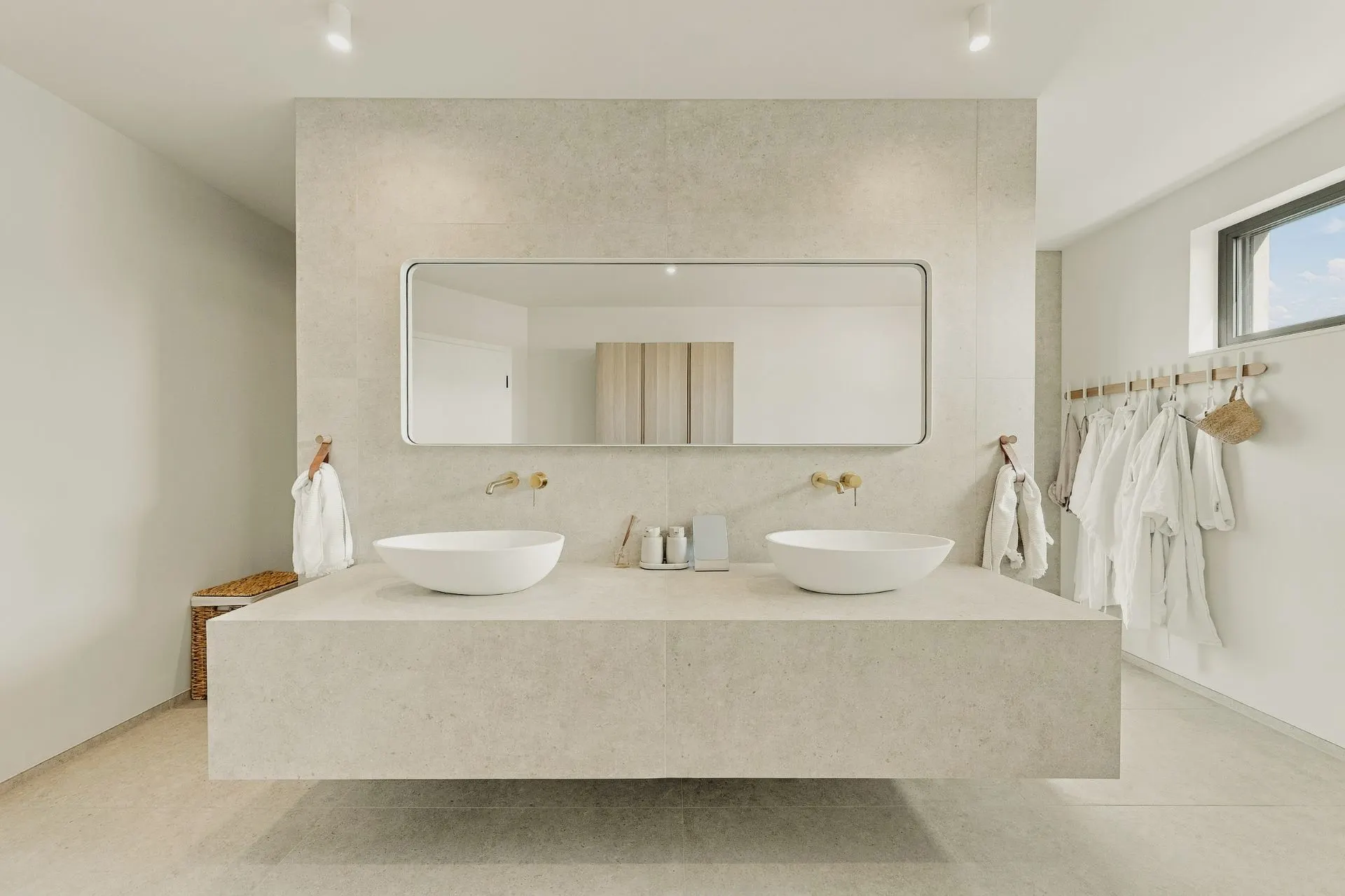 Modernes Badezimmer mit zwei Waschbecken, großem Spiegel und hellen Wänden.
