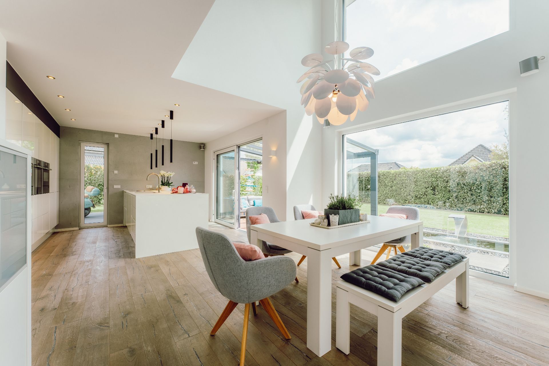 Helle, moderne Küche und Essbereich mit großen Fenstern und Holzboden.