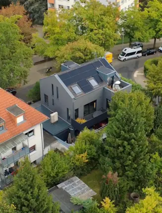 Modernes Wohnzimmer mit Kamin, offener Küche, großen Fenstern und Bartresen mit Hockern.