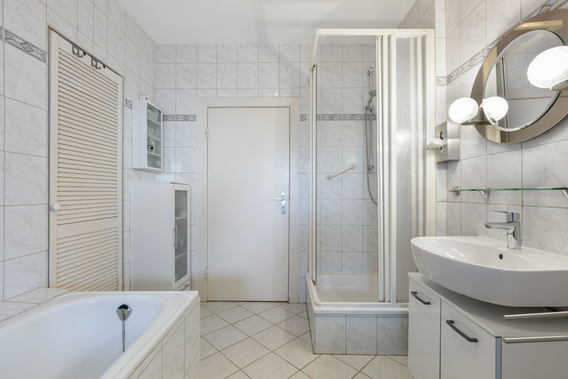 Modernes Badezimmer mit Dusche, Badewanne, Waschbecken und Spiegel.