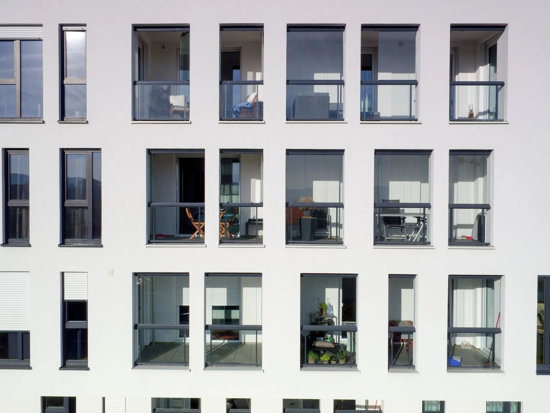 Fassade eines modernen Wohngebäudes mit vielen Fenstern und Balkonen.
