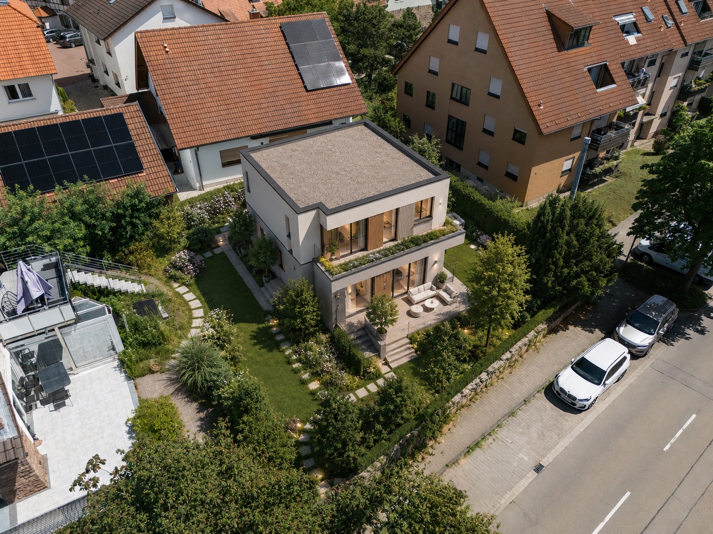 Modernes zweistöckiges Haus mit flachem Dach und gepflegtem Garten, aus der Vogelperspektive.