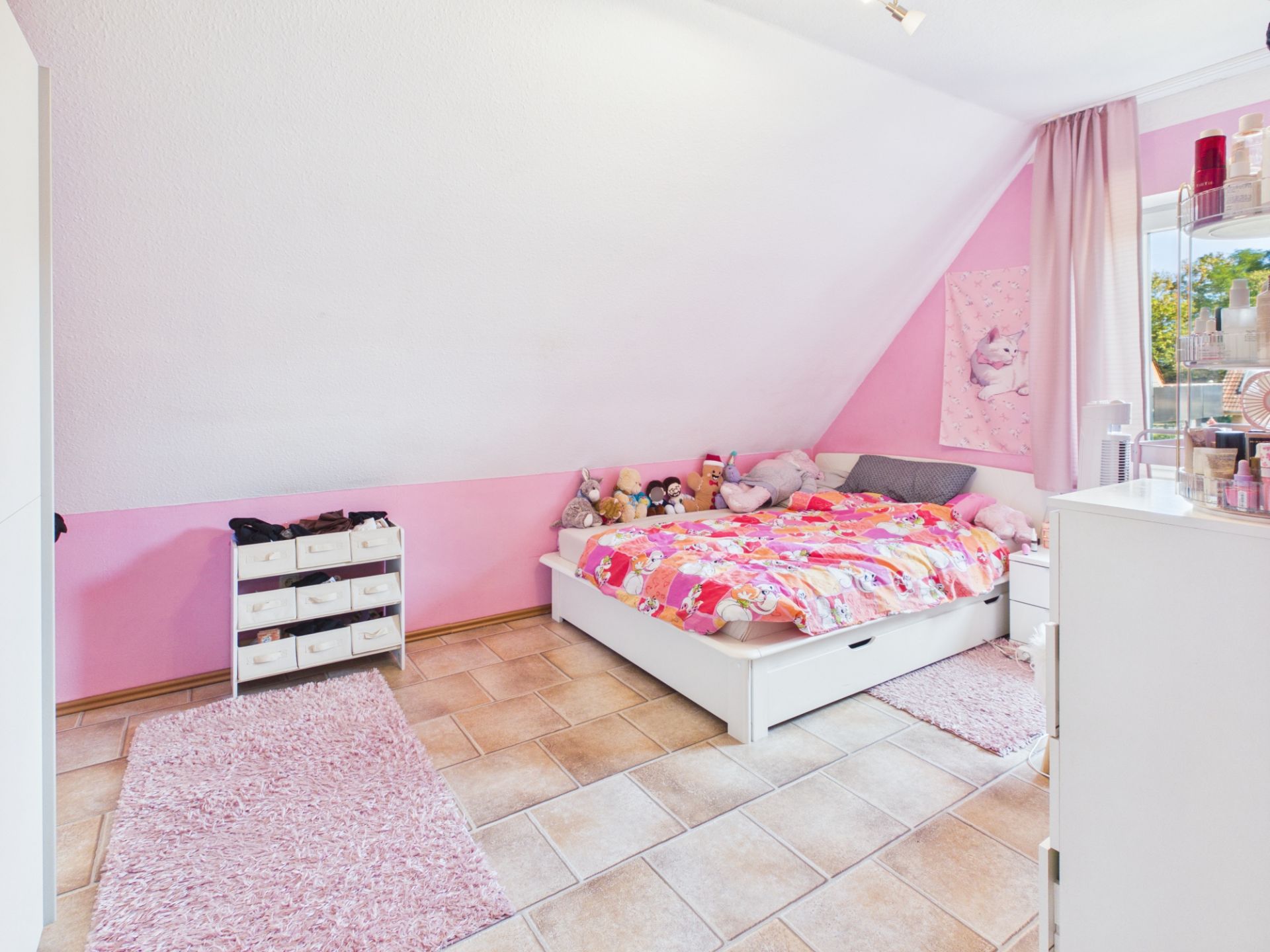 Helles Kinderzimmer mit rosa Wänden, Einzelbett, Plüschtieren und Teppichen.