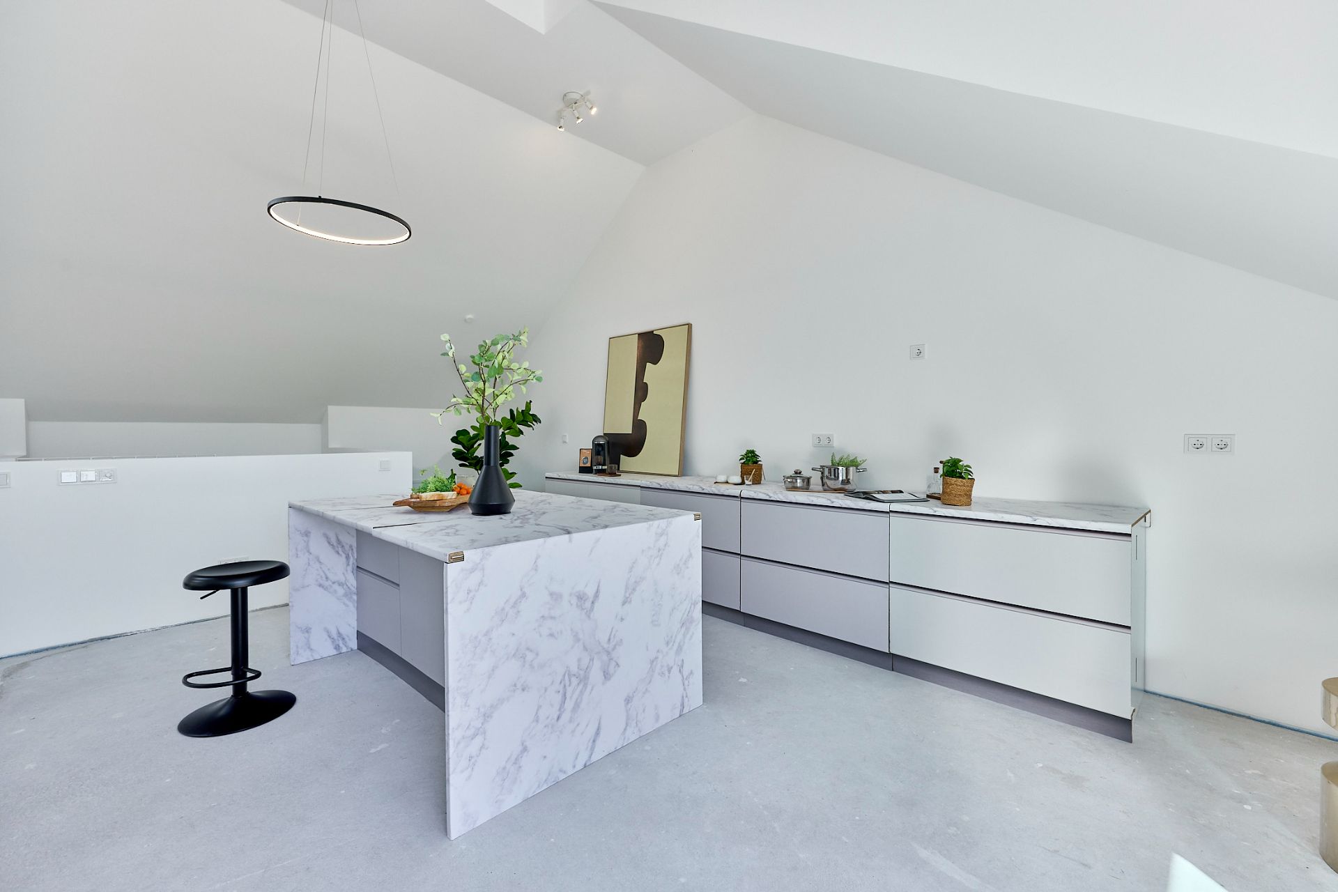 Moderne weiße Küche mit Kochinsel, Hockern und Dekoration auf der Arbeitsfläche.