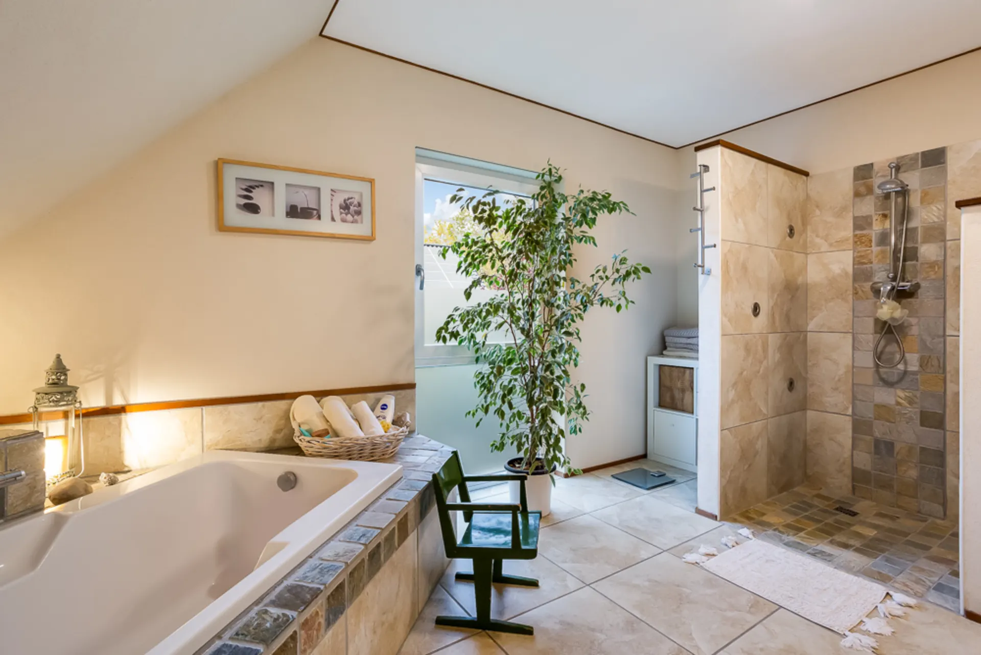 Modernes Badezimmer mit Badewanne, offener Dusche, Pflanze und großem Fenster.