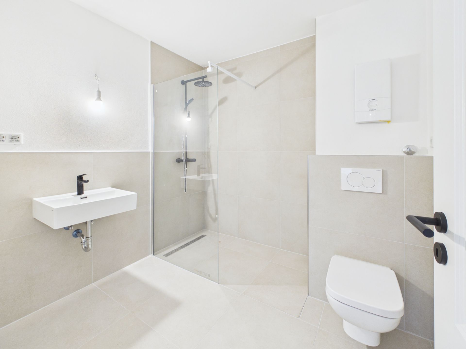 Modernes, helles Badezimmer mit Waschbecken, Dusche und Hängetoilette.