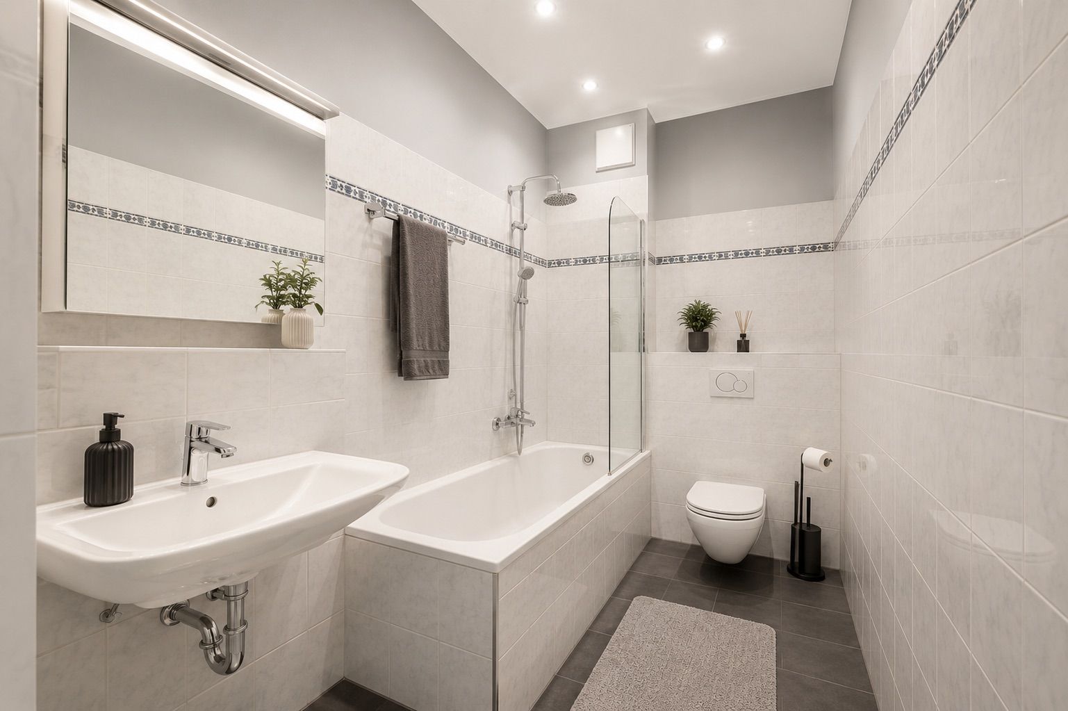Modernes Badezimmer mit Badewanne, Waschbecken, Toilette und hellen Fliesen.