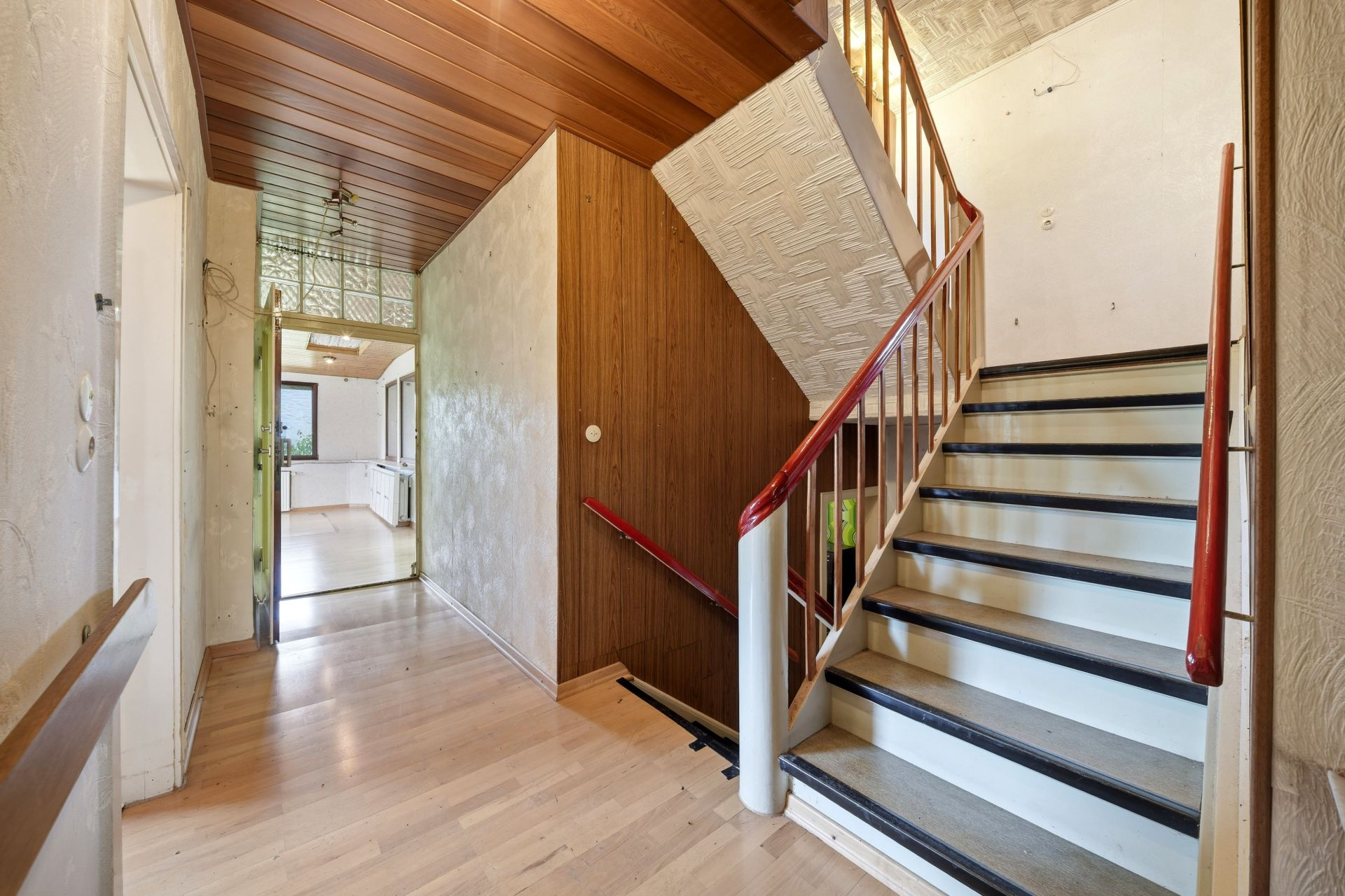 Heller Flur mit Holzdecke, Treppe nach oben und Blick in die Küche.