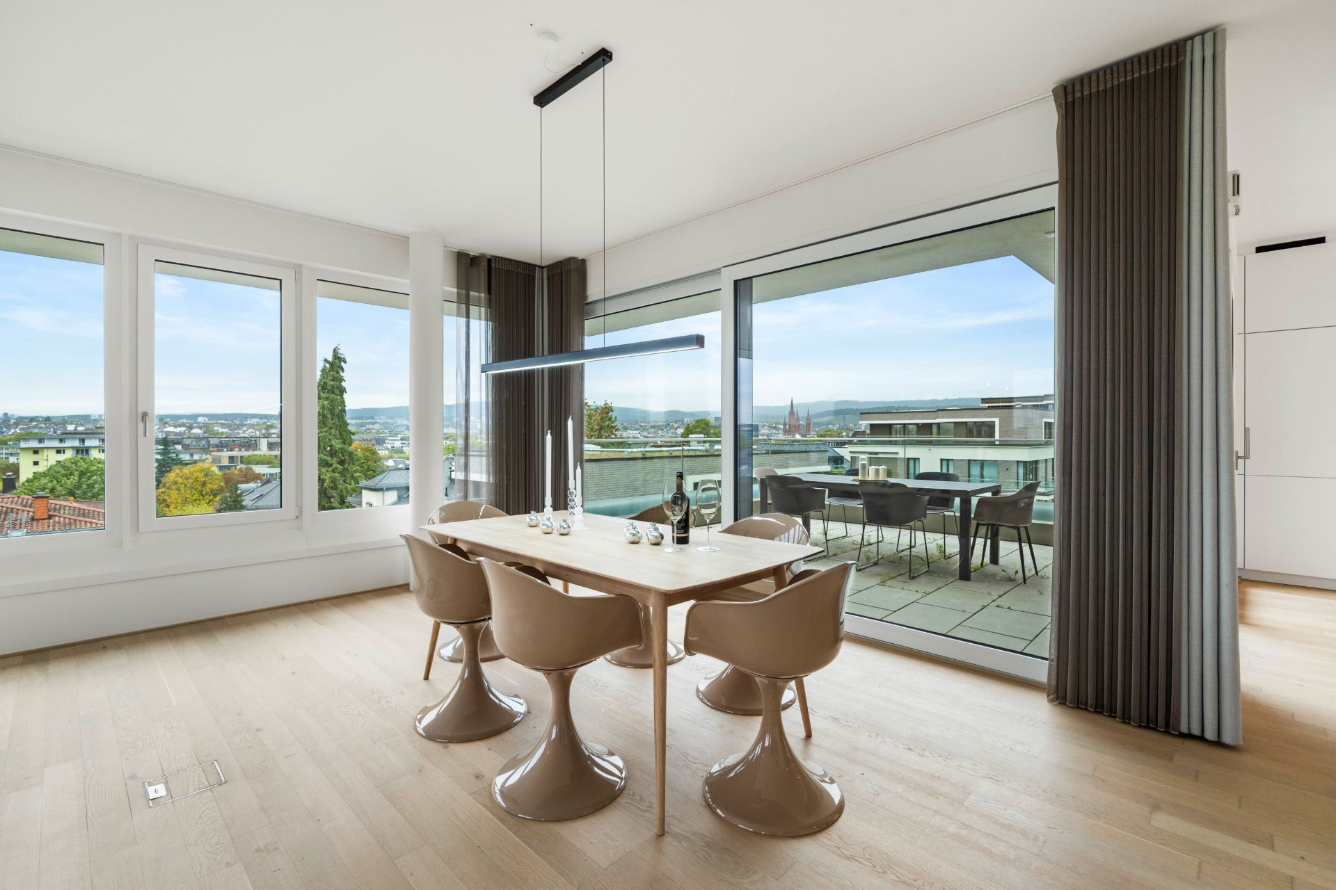 Essbereich mit modernem Tisch, vier Stühlen, großen Fenstern und Zugang zum Balkon.