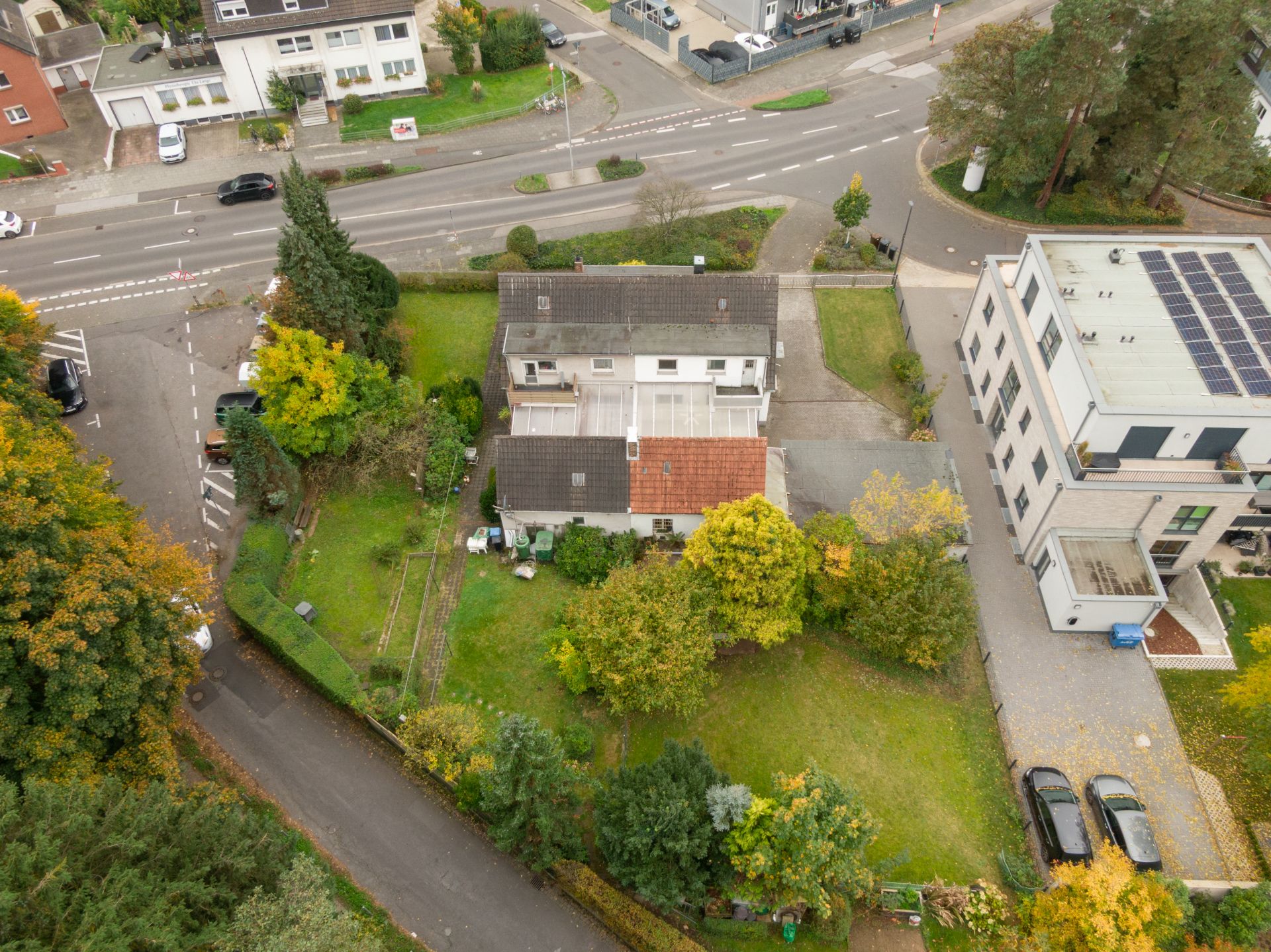 Luftaufnahme eines Wohnhauses mit großem Garten und angrenzender Straße.