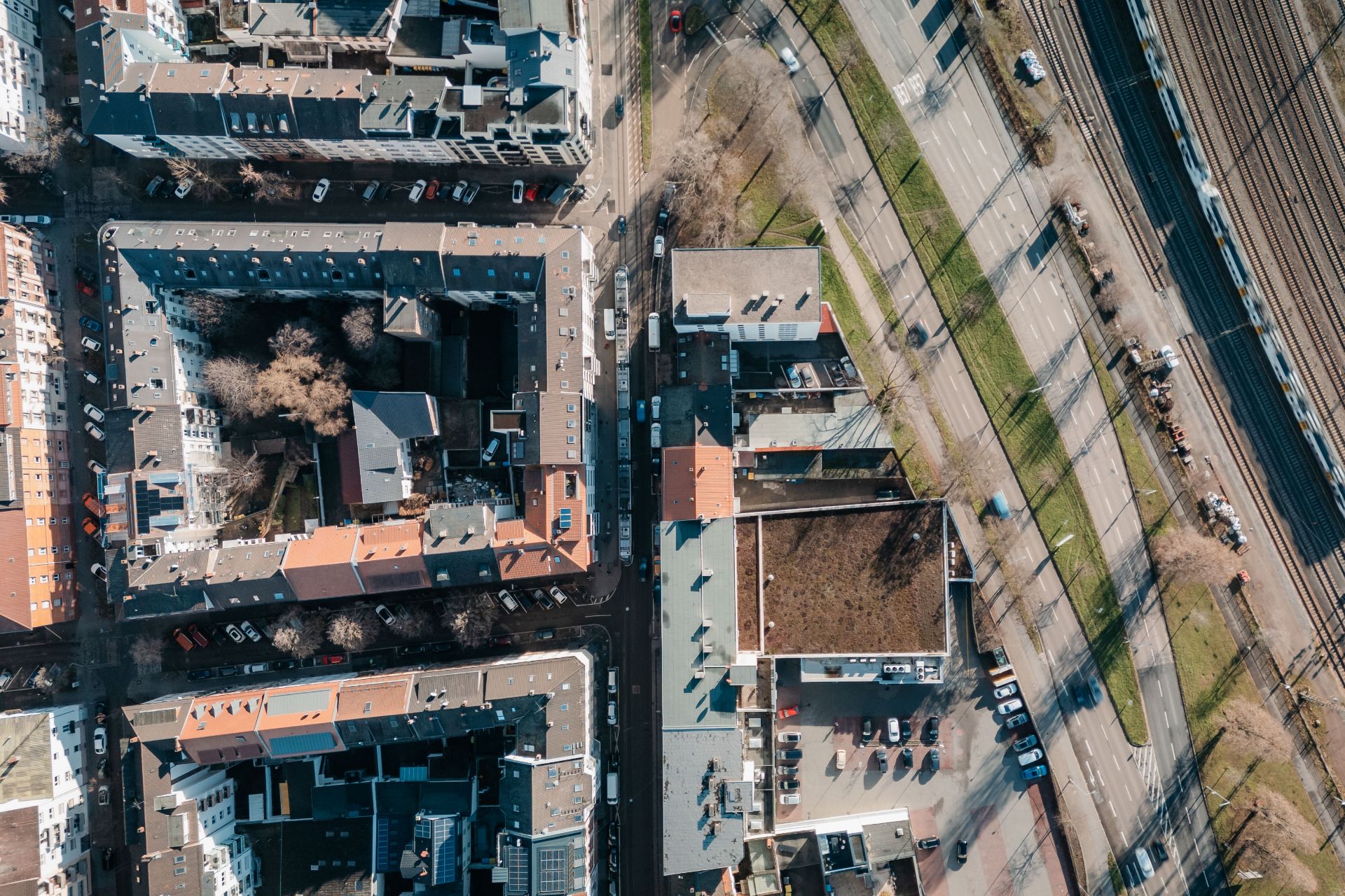 Luftaufnahme von Wohngebäuden, Straßen und parkenden Autos in einer Stadt.