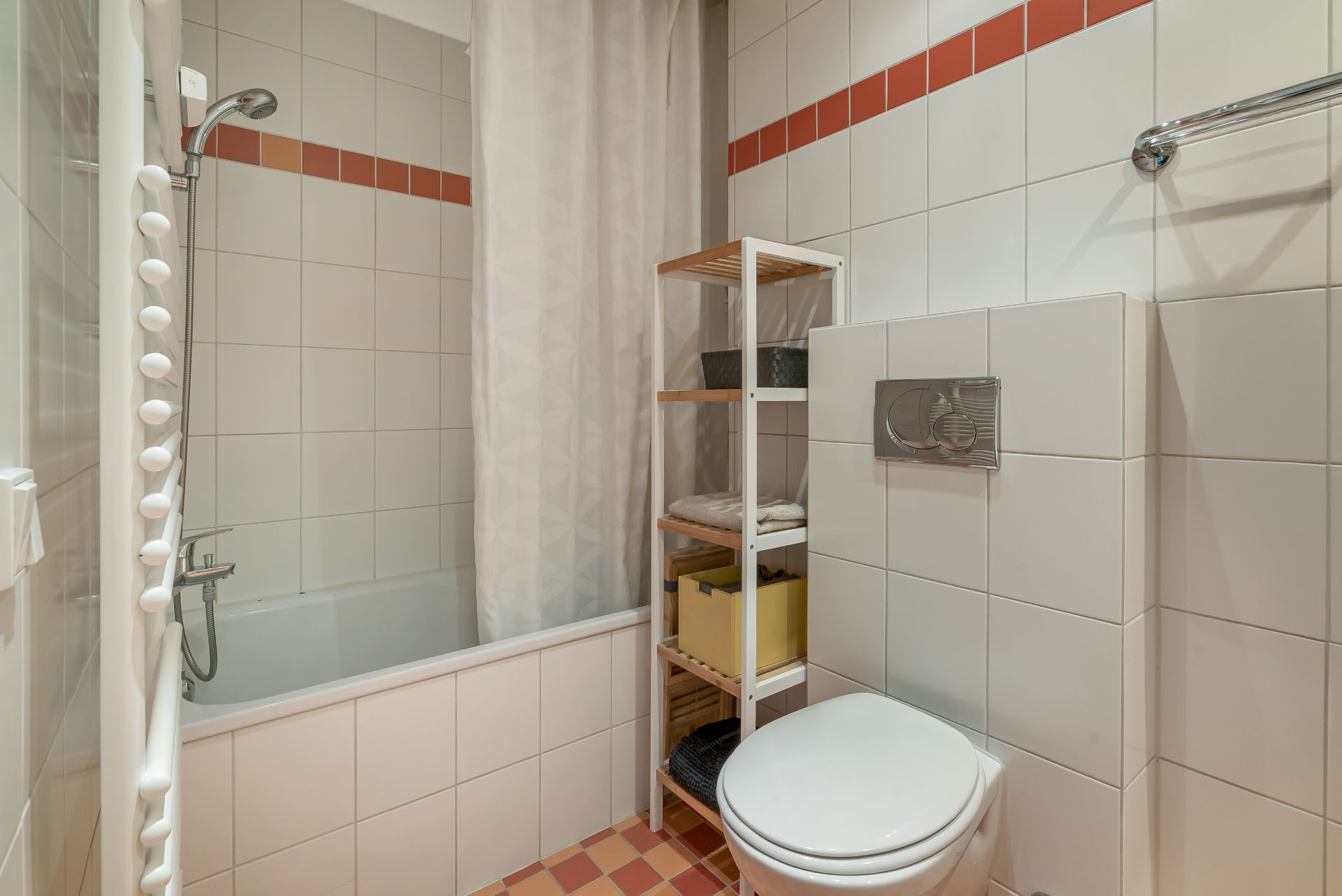 Helles Bad mit Badewanne, Duschvorhang, WC und Regal mit Handtüchern.