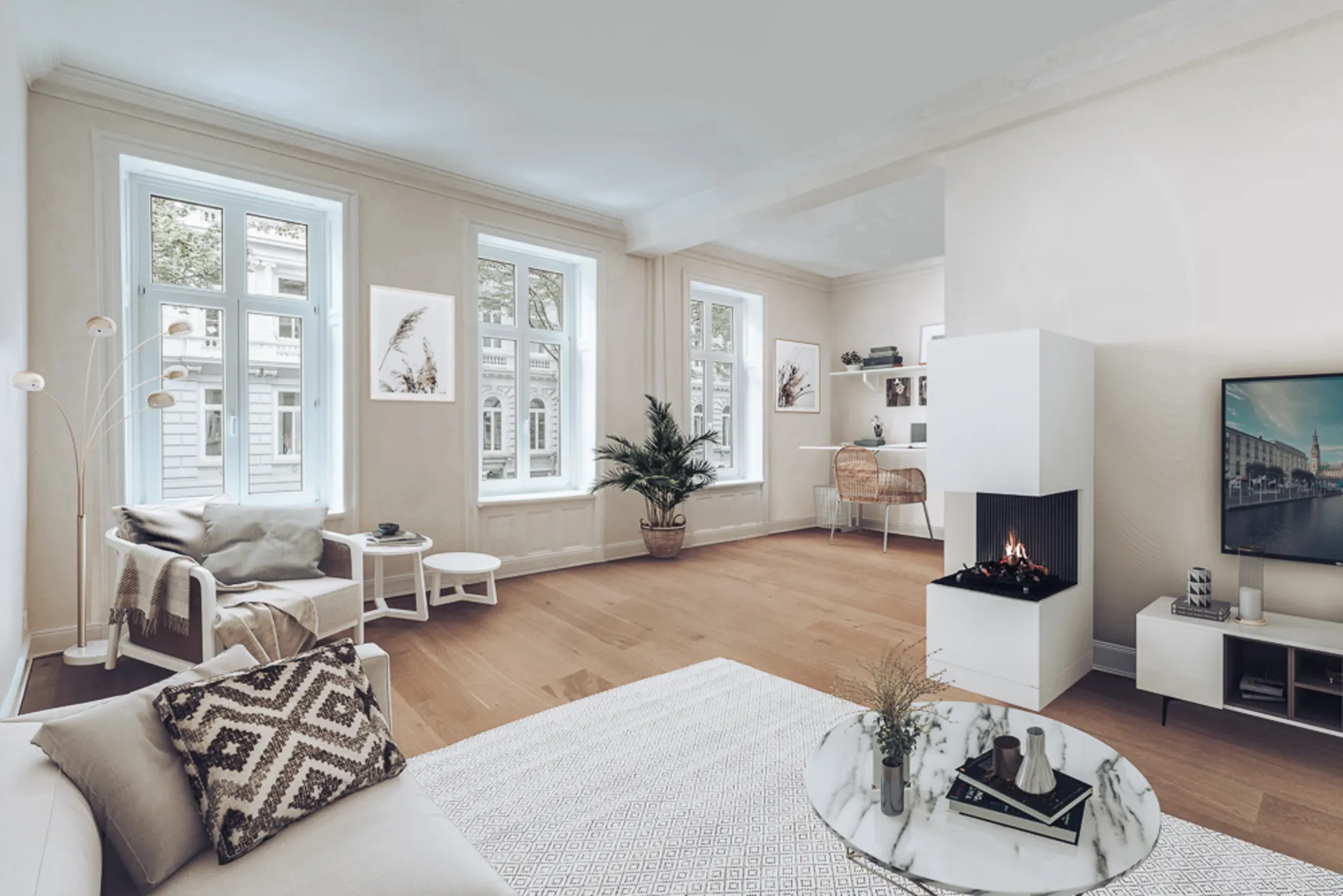 Helles Wohnzimmer mit Sofa, Sessel, Kamin, Schreibtisch und großen Fenstern.