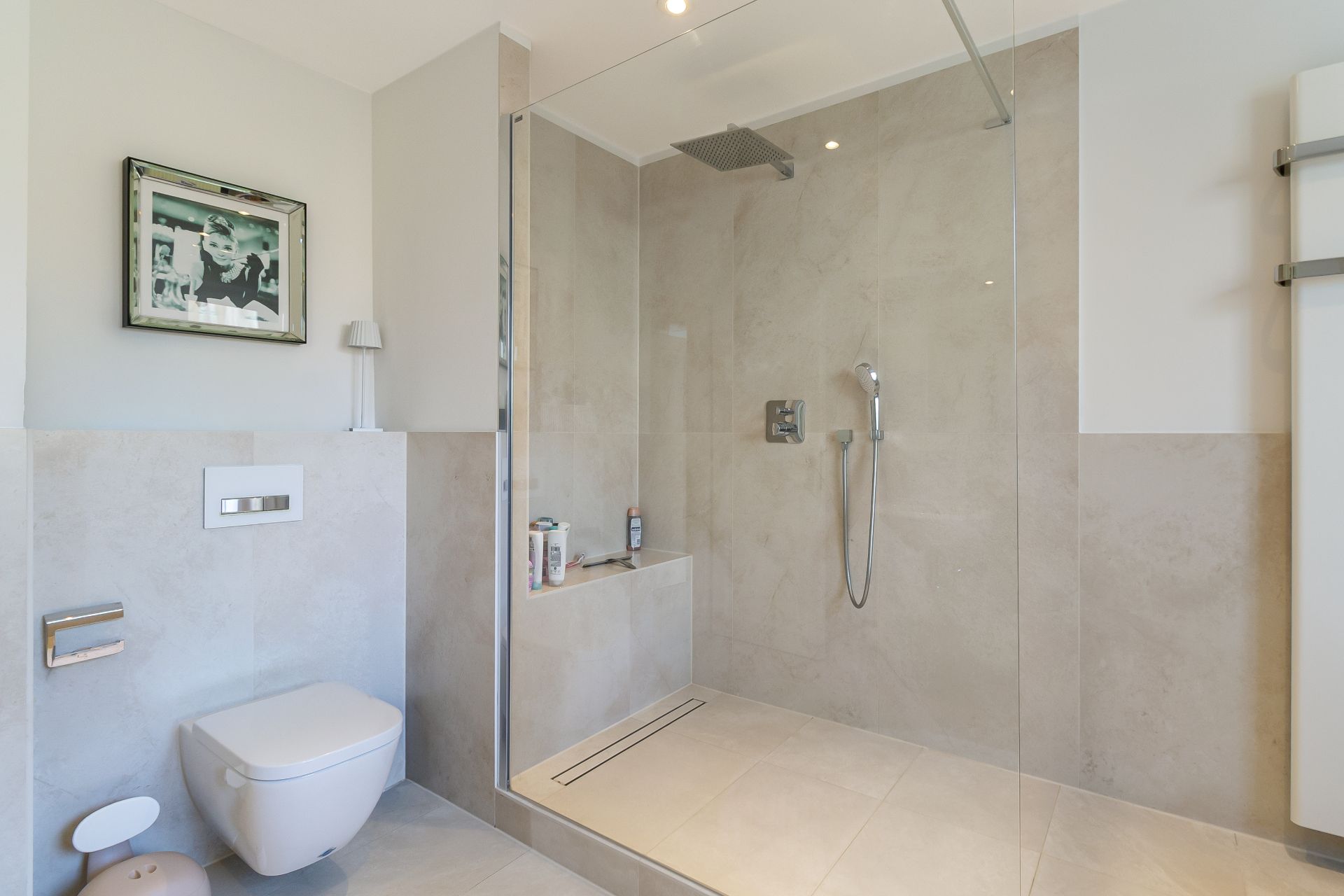 Modernes Badezimmer mit bodengleicher Dusche, WC und Wandbild.