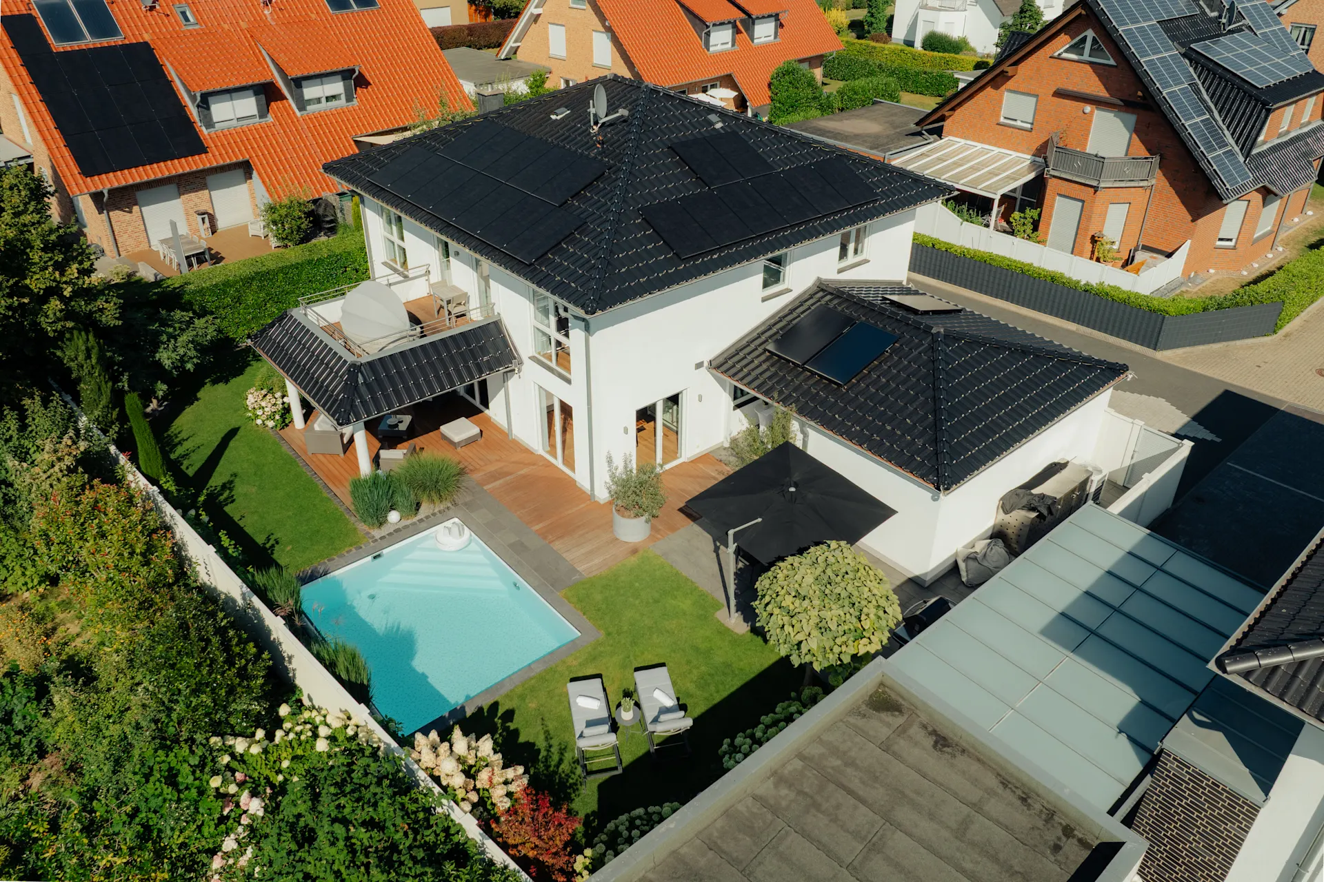 Modernes Wohnhaus mit Garten, Pool und Sonnenkollektoren auf dem Dach, aus der Vogelperspektive.