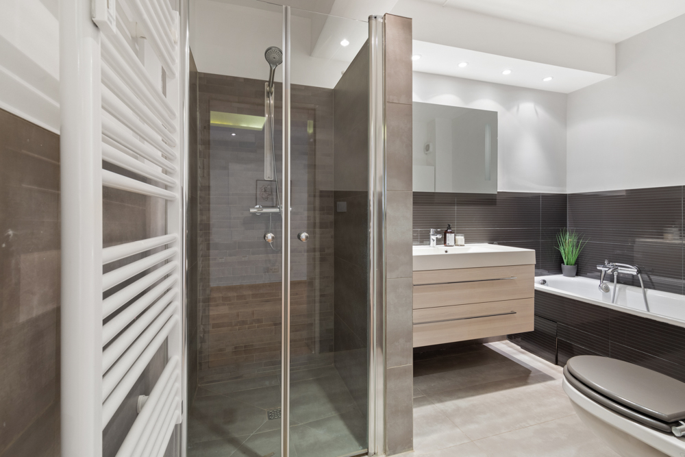 Modernes Badezimmer mit Dusche, Waschbecken, Badewanne und Toilette.