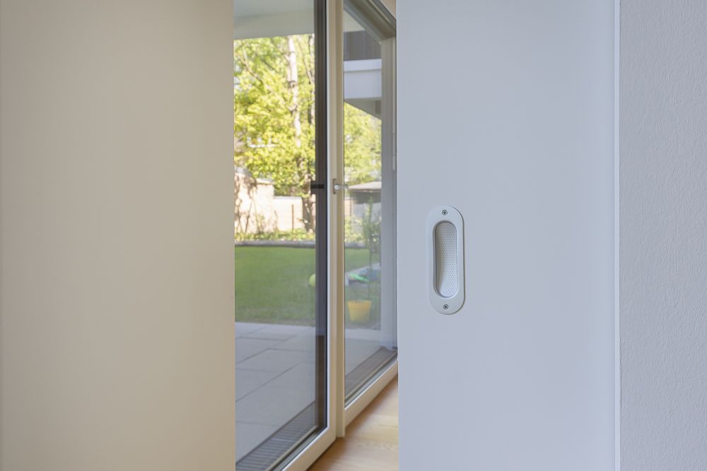 Schiebetür in hellem Raum mit Blick auf Terrasse und Garten.
