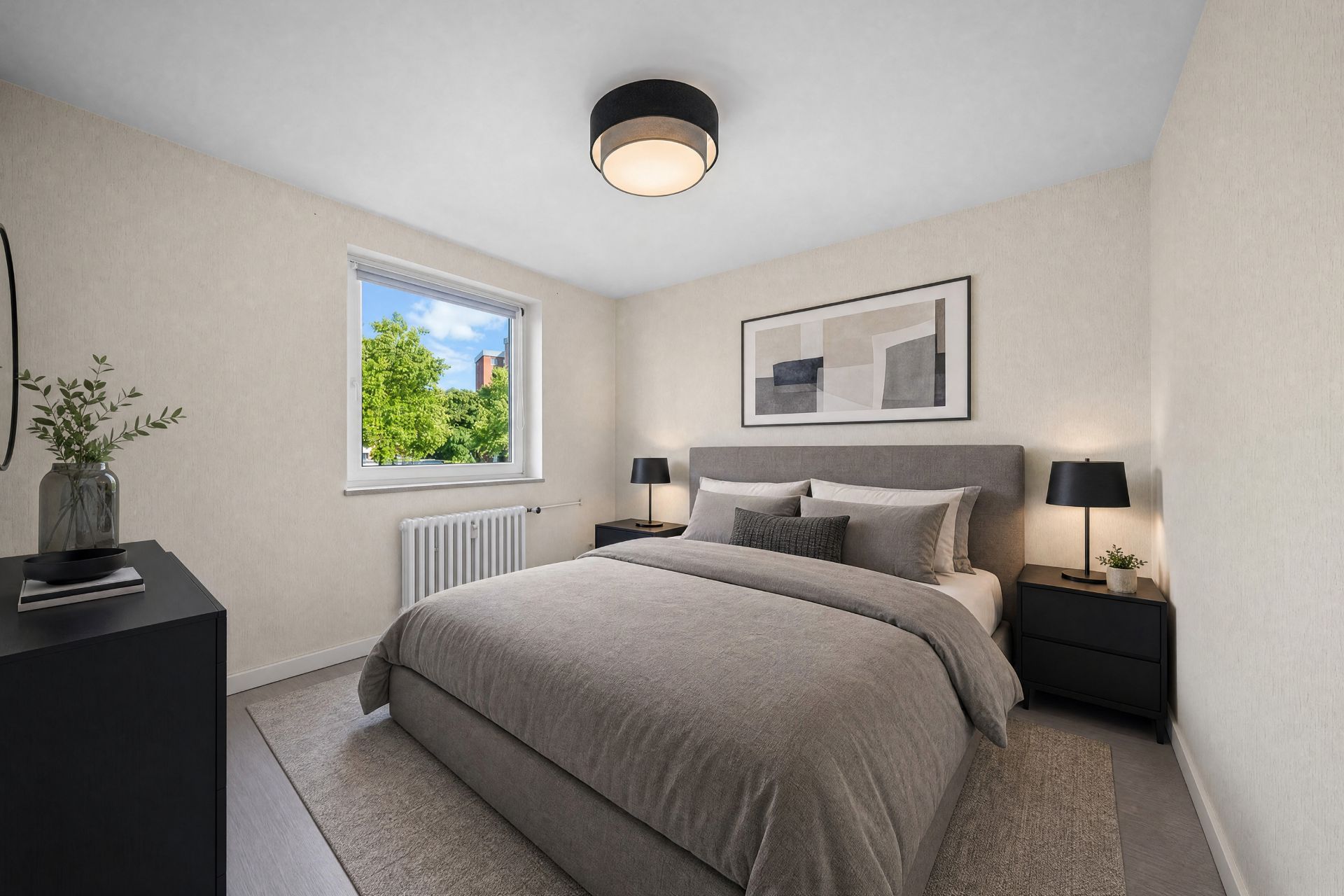 Schlafzimmer mit großem Bett, zwei Nachttischen und Fenster mit Blick ins Grüne.