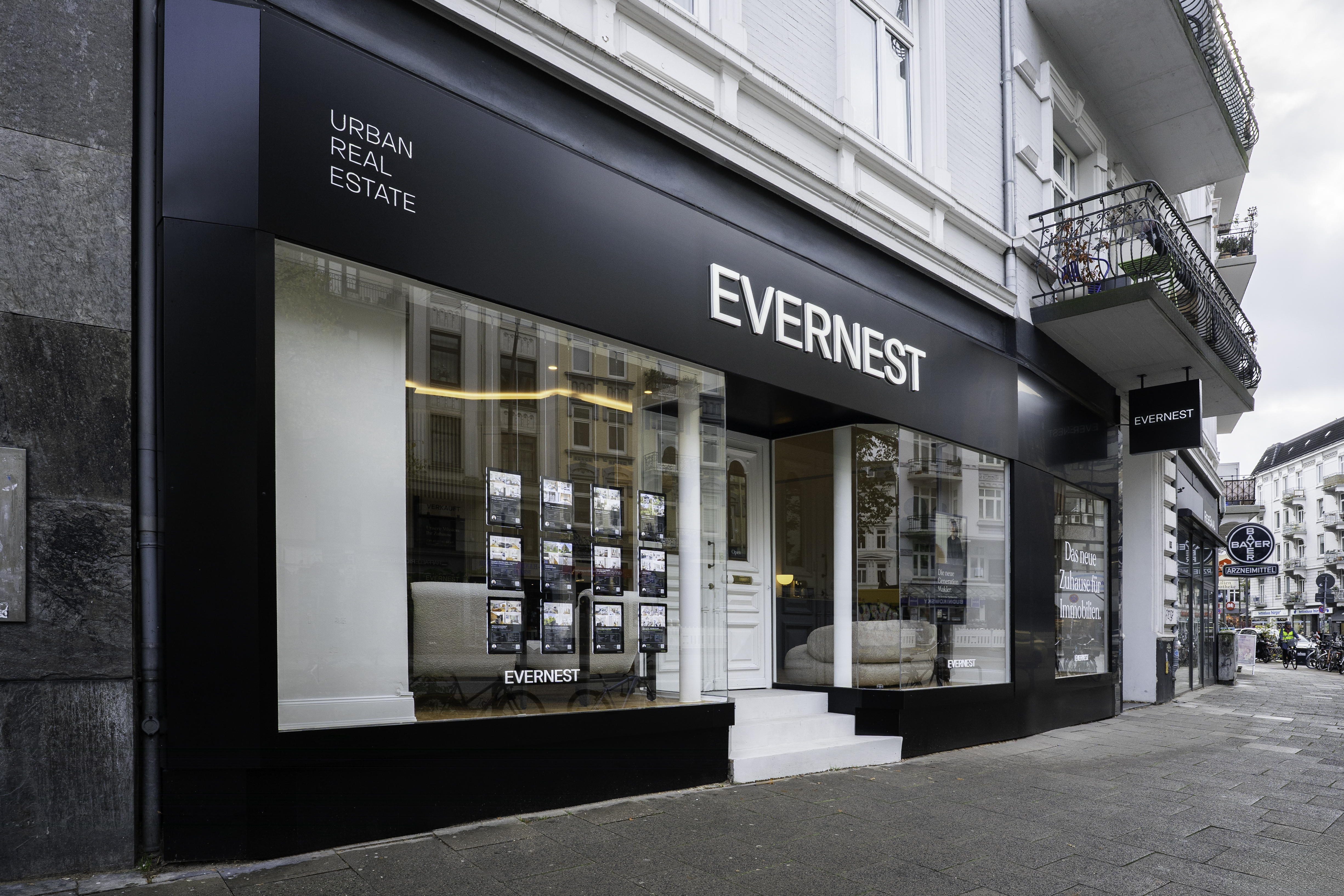 Eingang und Schaufenster eines Immobilienbüros mit der Aufschrift EVERNEST an einer Straßenecke.