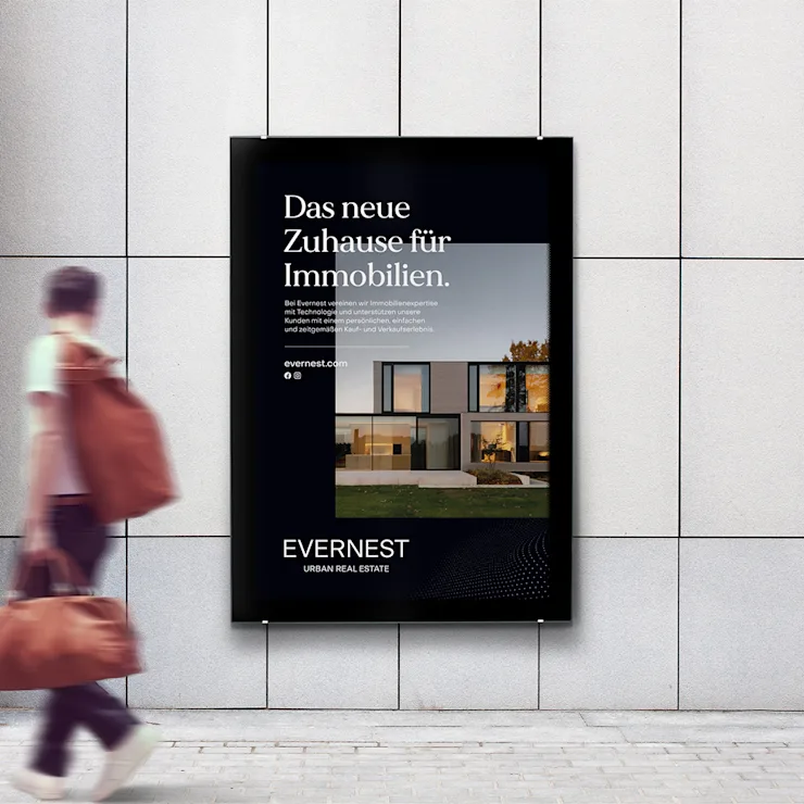 Werbeplakat mit modernem Wohnhaus und Text, daneben geht eine Person mit einer Tasche vorbei.