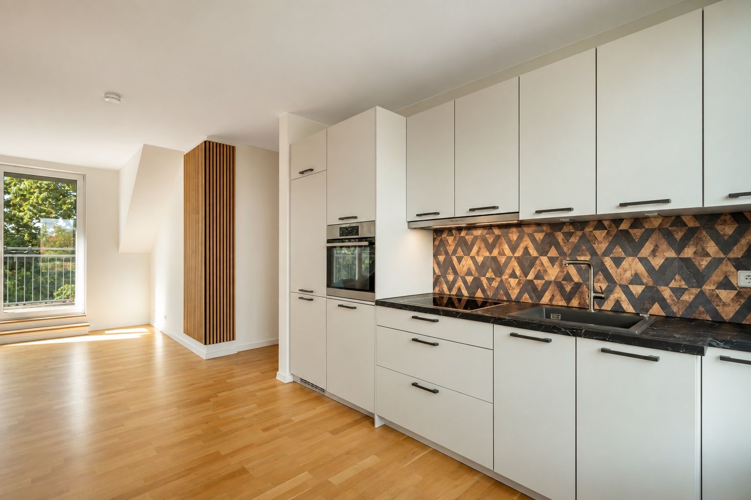 Moderne Küche mit weißen Schränken, gemustertem Fliesenspiegel und Holzfußboden, Fenster im Hintergrund.