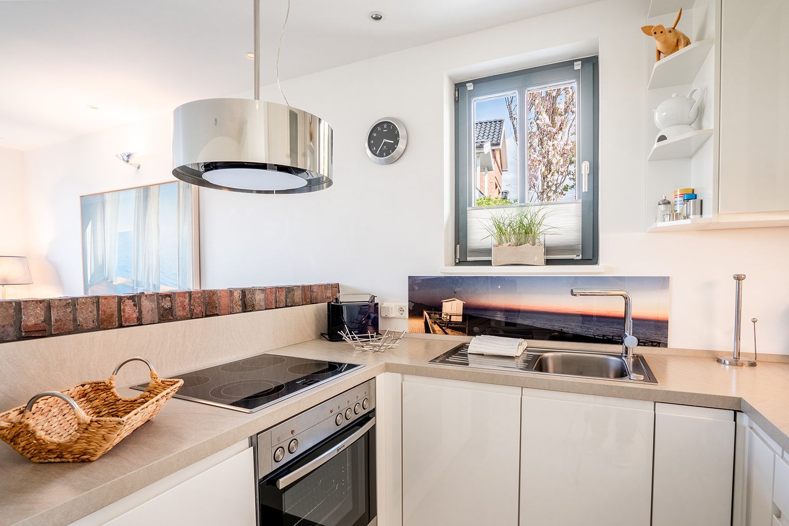 Helle moderne Küche mit Herd, Spüle, Fenster und Dekorationen auf der Arbeitsfläche.