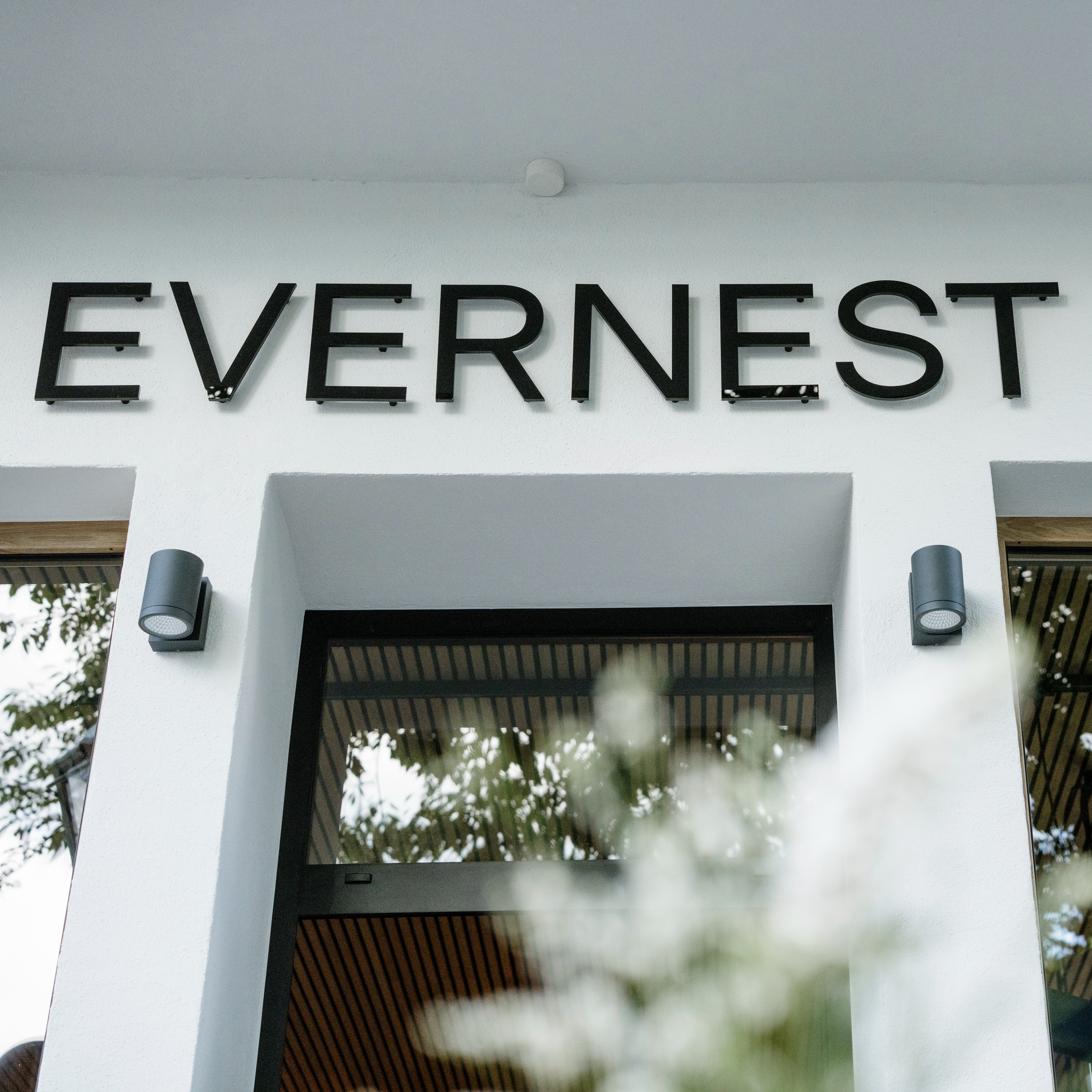 Eingangsbereich eines Gebäudes mit dem Schriftzug 'EVERNEST' über der Tür.