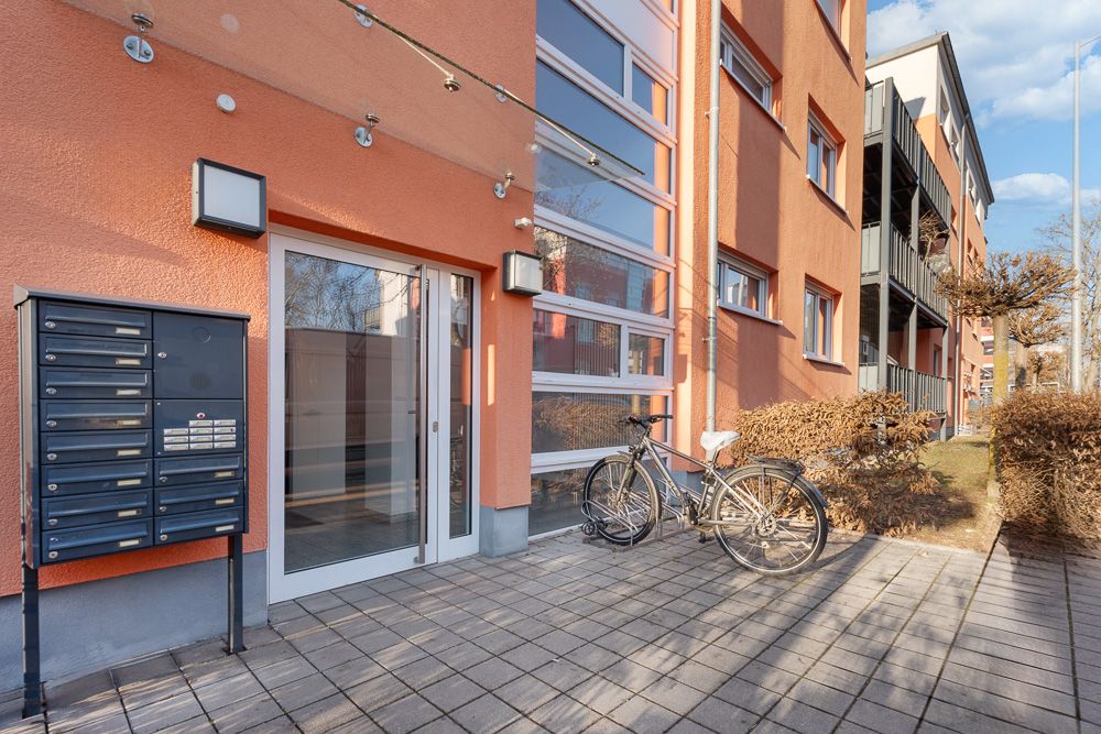 Eingang eines Wohnhauses mit Briefkästen und einem Fahrrad daneben.