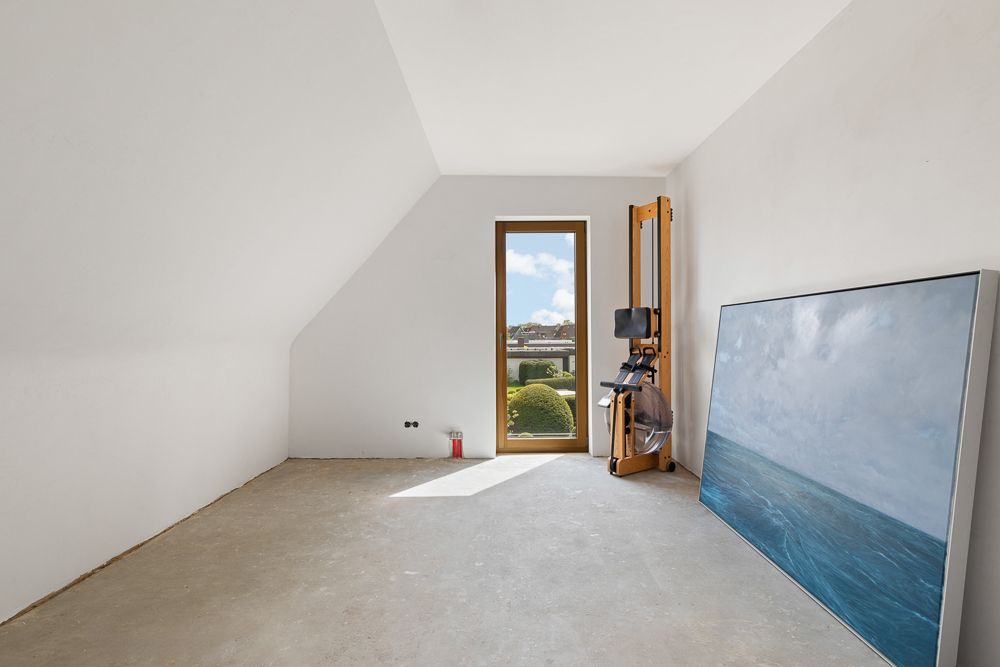 Leerer Raum mit Fenster, Rudergerät und großem Bild an der Wand