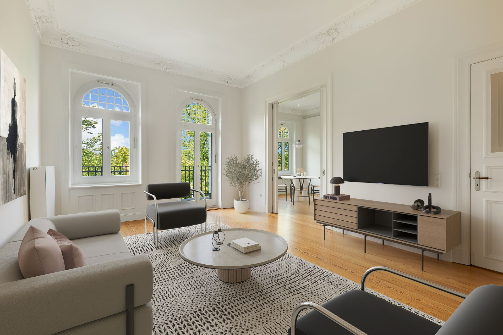 Helles Wohnzimmer mit Sofa, Sesseln, TV, Couchtisch und großen Fenstern, Holzboden, Zugang zum Esszimmer.