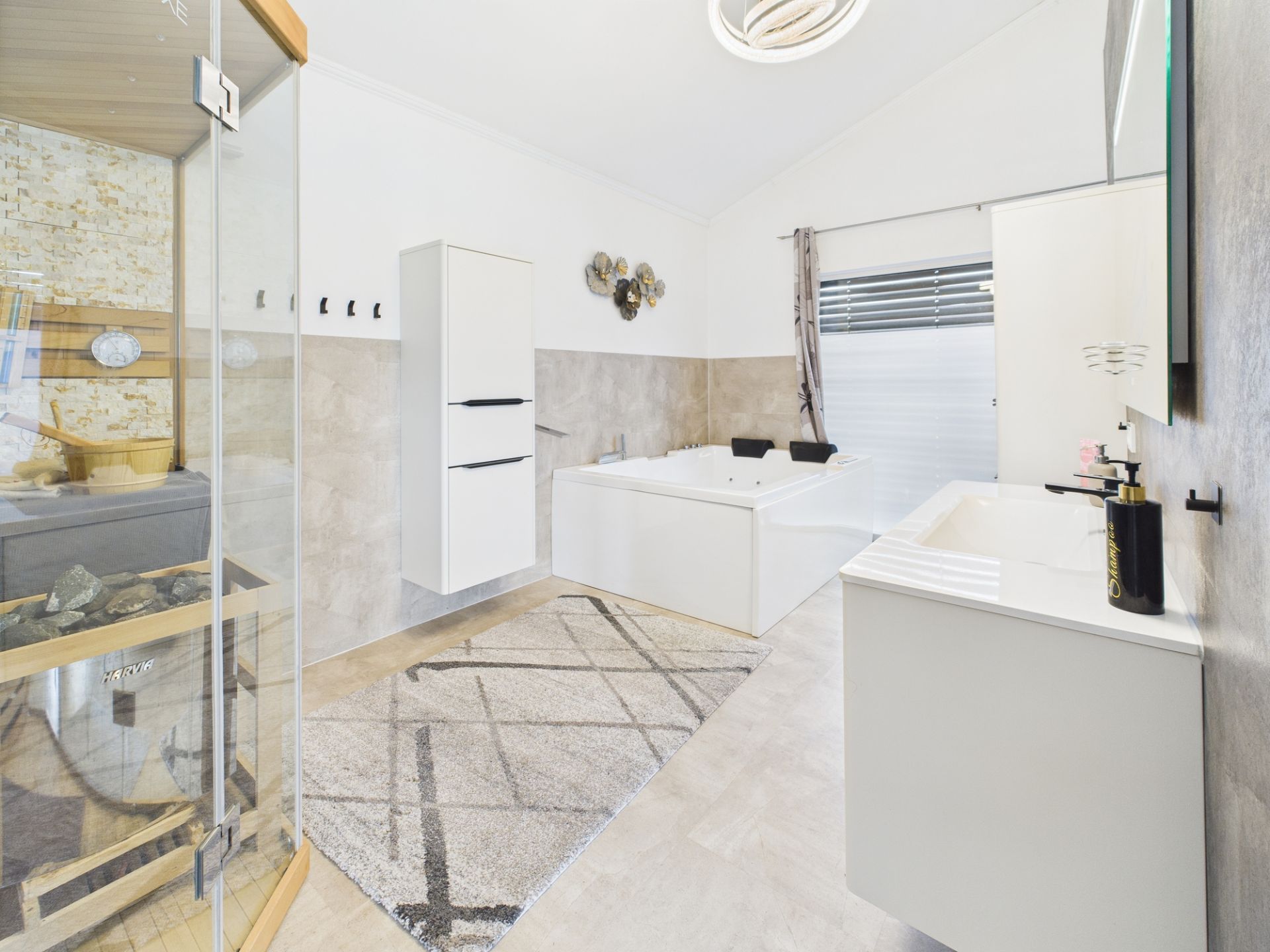 Modernes Badezimmer mit Dusche, Badewanne, Waschbecken und weißem Schrank.