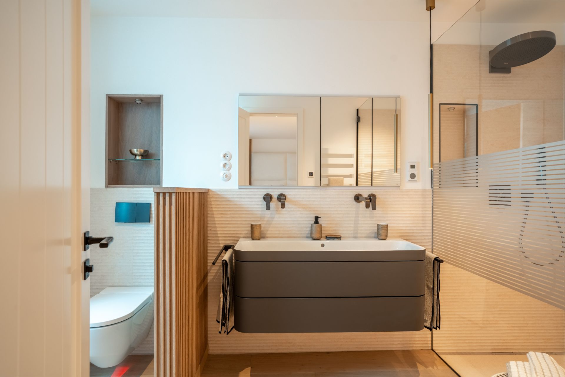 Modernes Badezimmer mit großem Spiegel, Waschbecken, Dusche und Toilette.