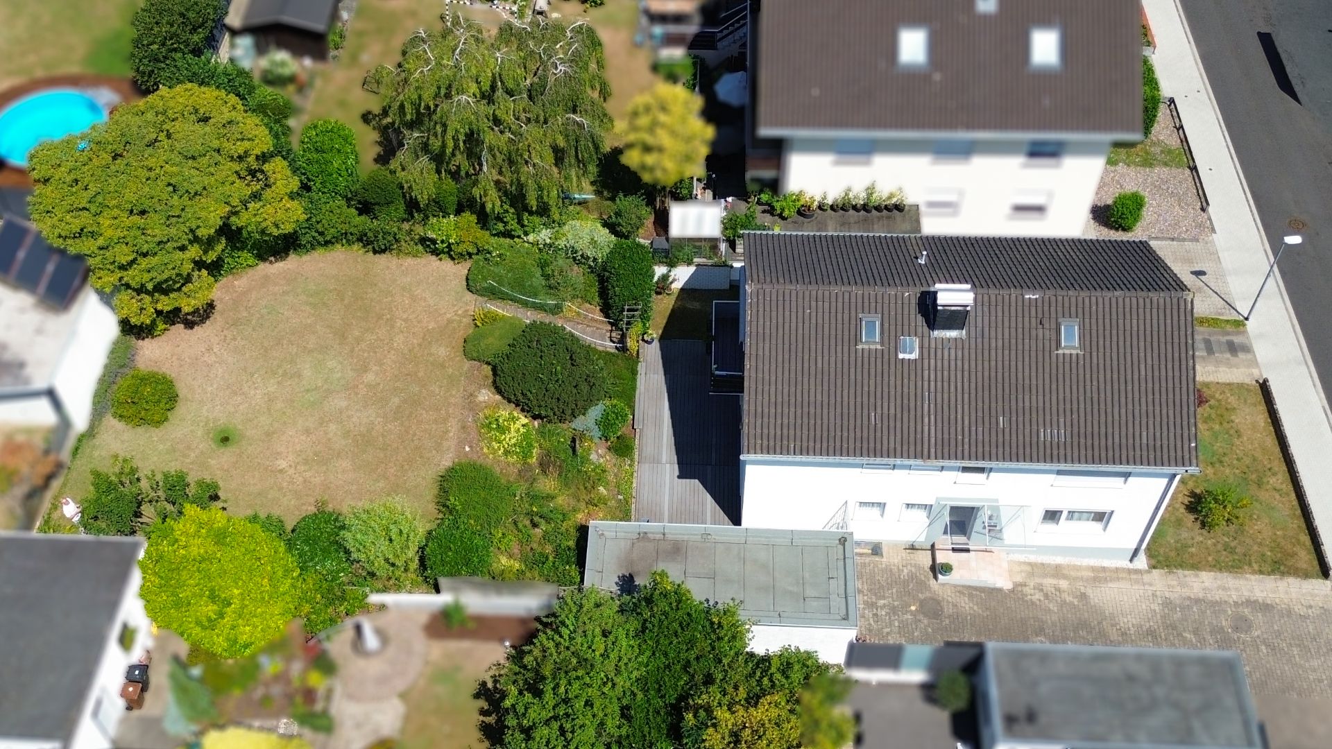 Luftaufnahme eines Wohnhauses mit großem Garten und umliegenden Pflanzen.