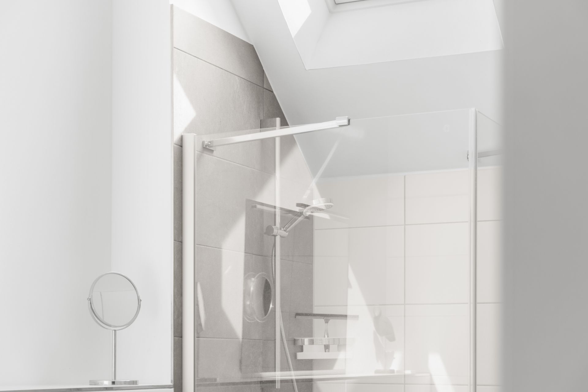 Modernes Badezimmer mit Dusche, Glaswand und Dachfenster.