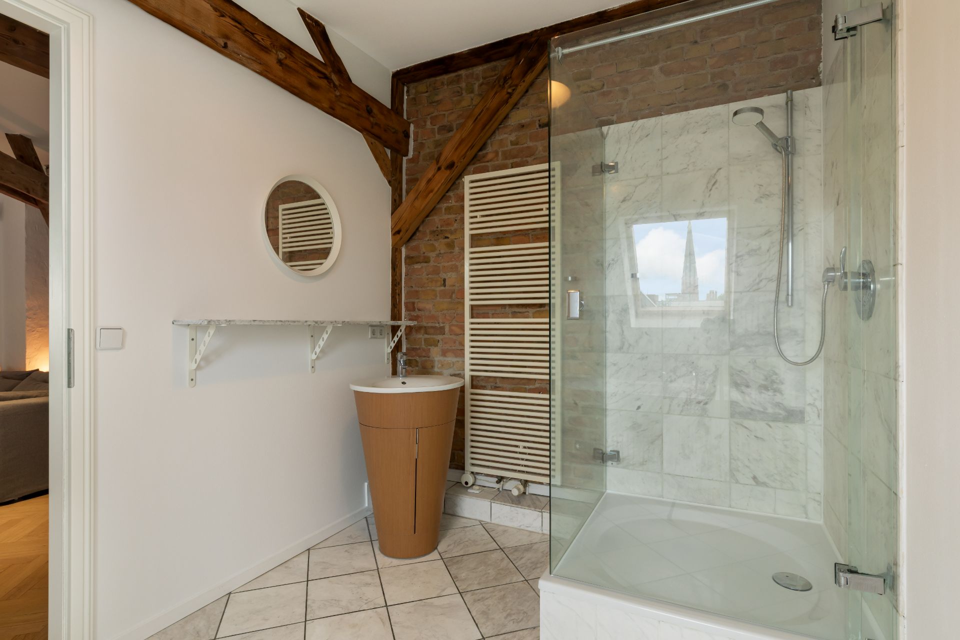 Modernes Badezimmer mit Dusche, rundem Waschbecken, Spiegel und sichtbaren Holzbalken.