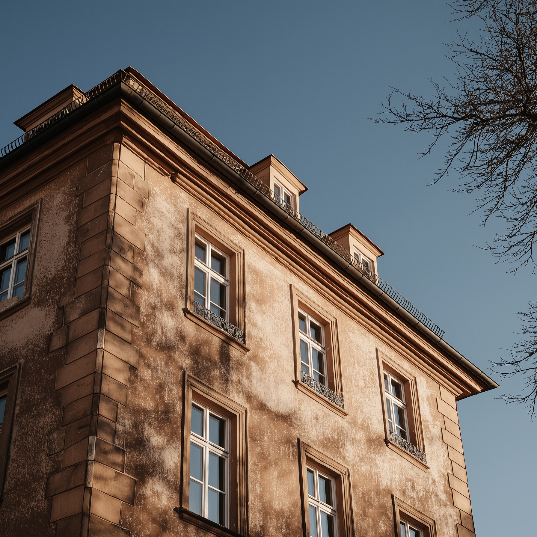 Außenansicht eines mehrstöckigen Wohngebäudes mit mehreren Fenstern bei Tageslicht.
