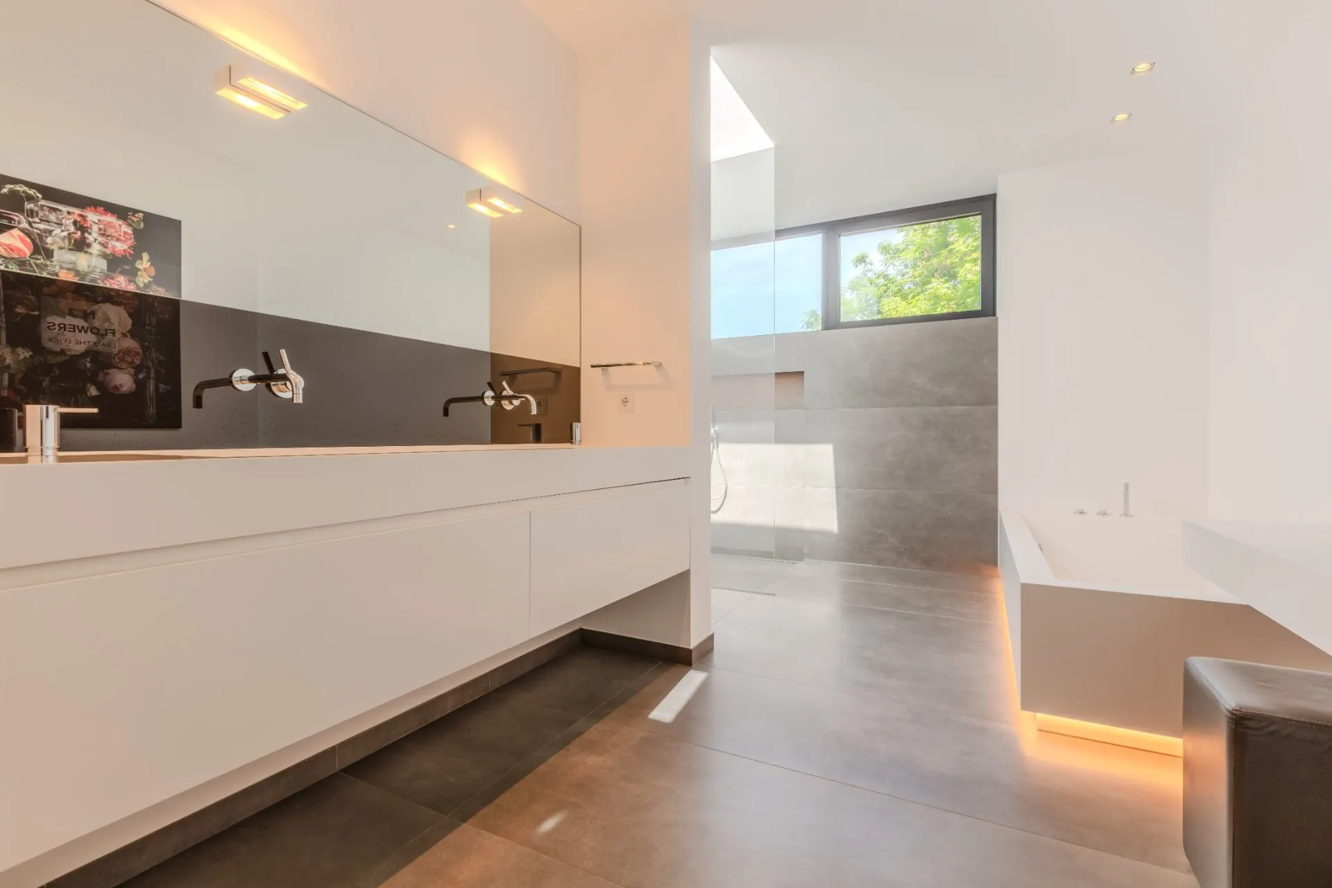 Modernes Badezimmer mit großem Spiegel, Doppelwaschbecken, Badewanne und großem Fenster.