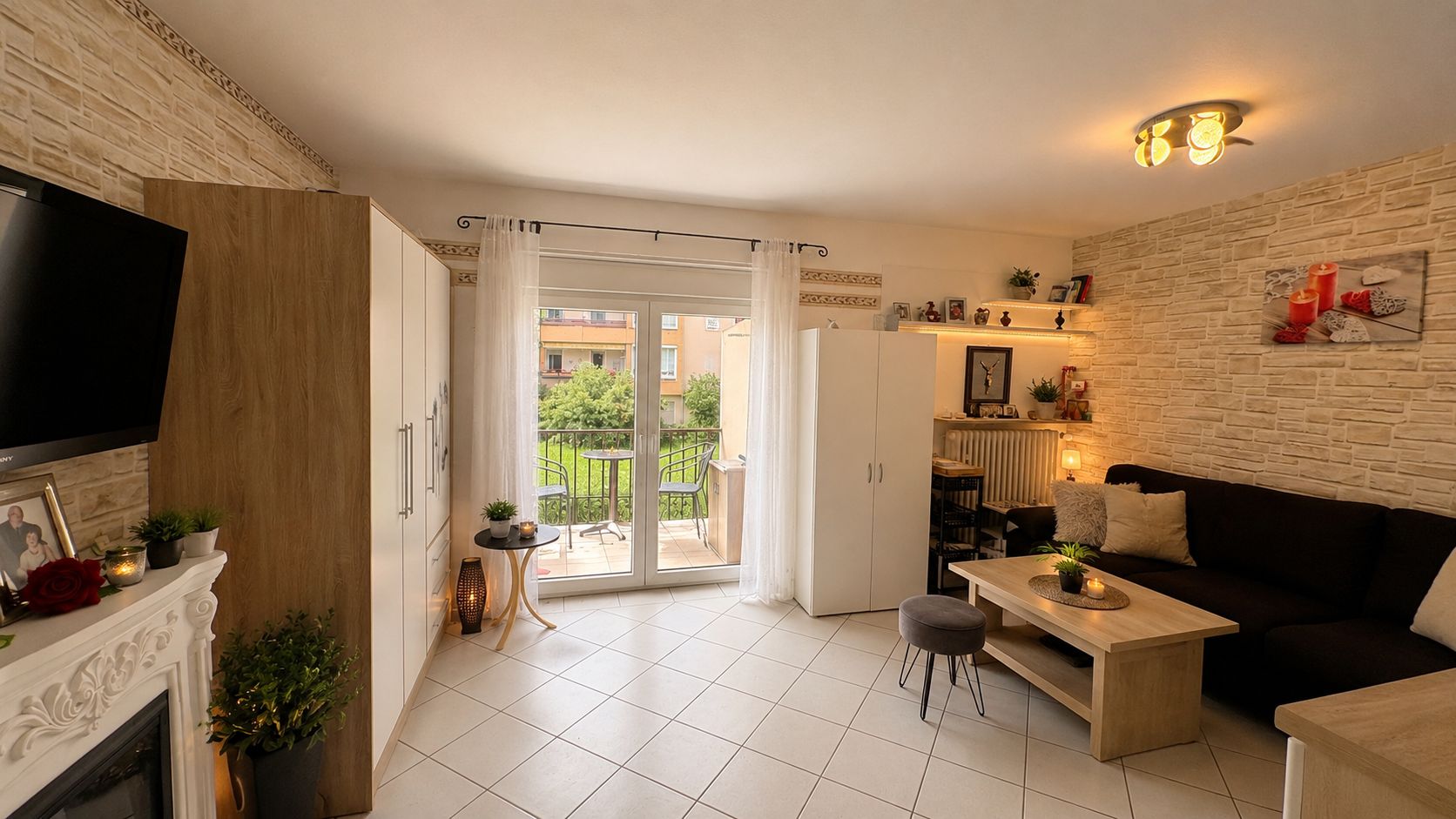 Helles Wohnzimmer mit Sofa, Couchtisch, Schrank und Balkonzugang.