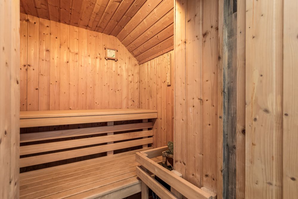 Innenansicht einer Sauna mit Holzbänken und Holzwänden.