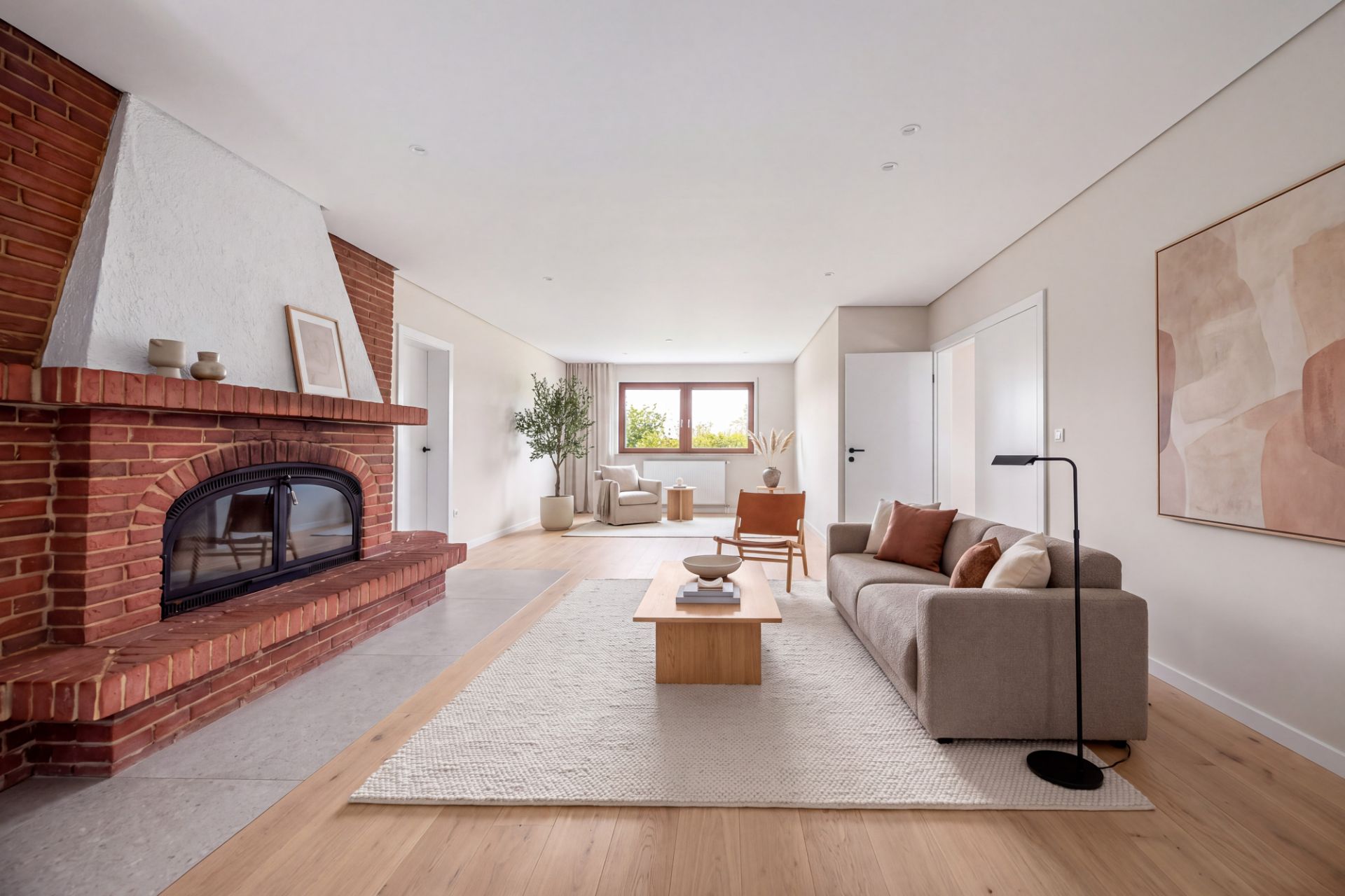 Helles Wohnzimmer mit Kamin, Sofa, Couchtisch und großen Fenstern, moderne Dekoration.