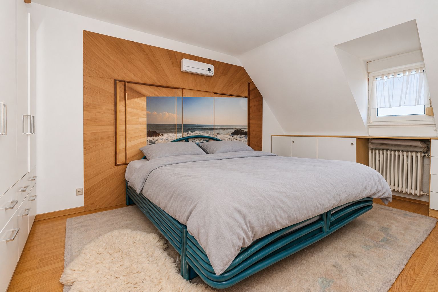 Schlafzimmer mit Doppelbett, Holzverkleidung und großem Wandbild hinter dem Bett.