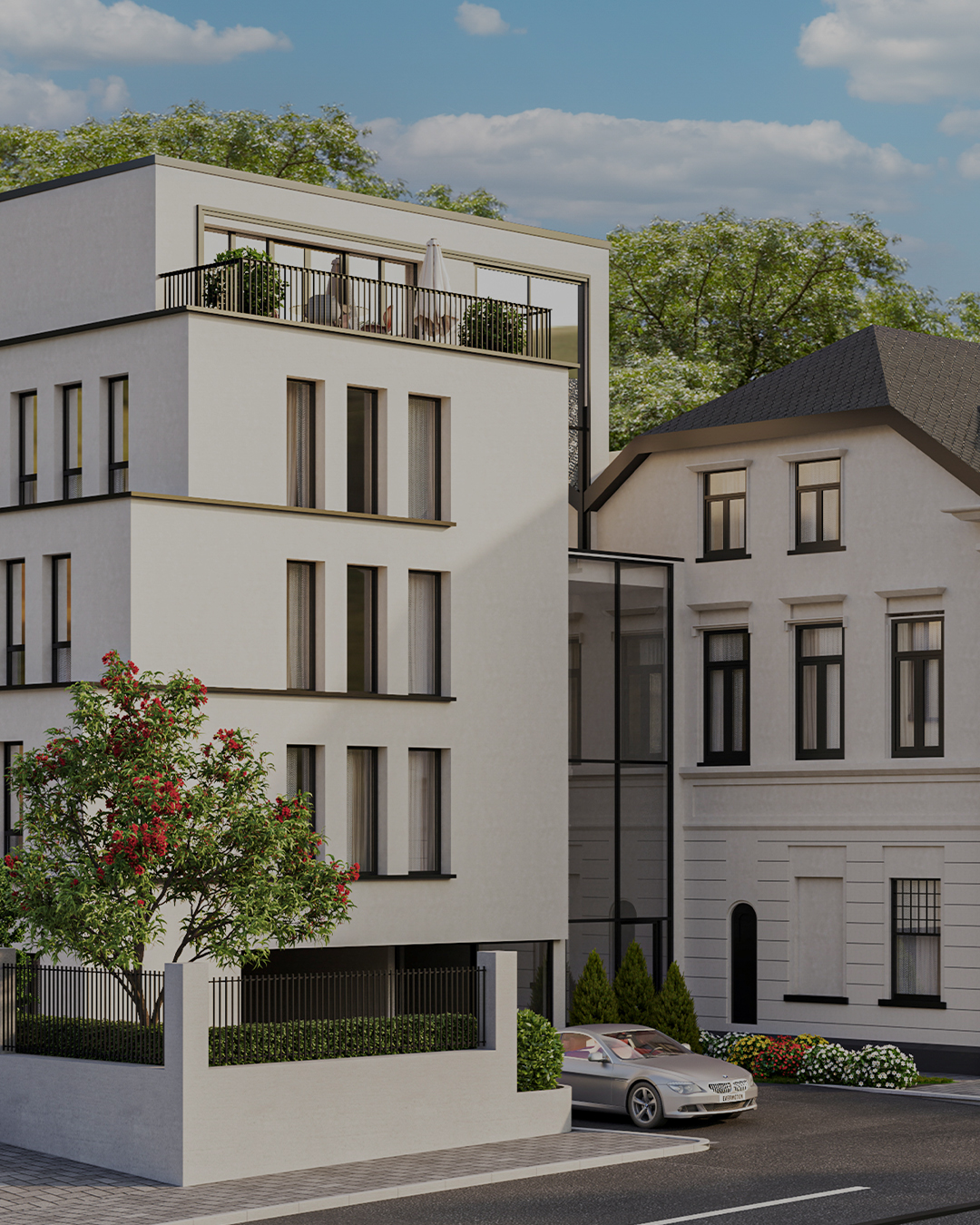 Modernes Wohngebäude mit großem Balkon und Baum davor, daneben ein weiteres Haus und ein geparktes Auto.