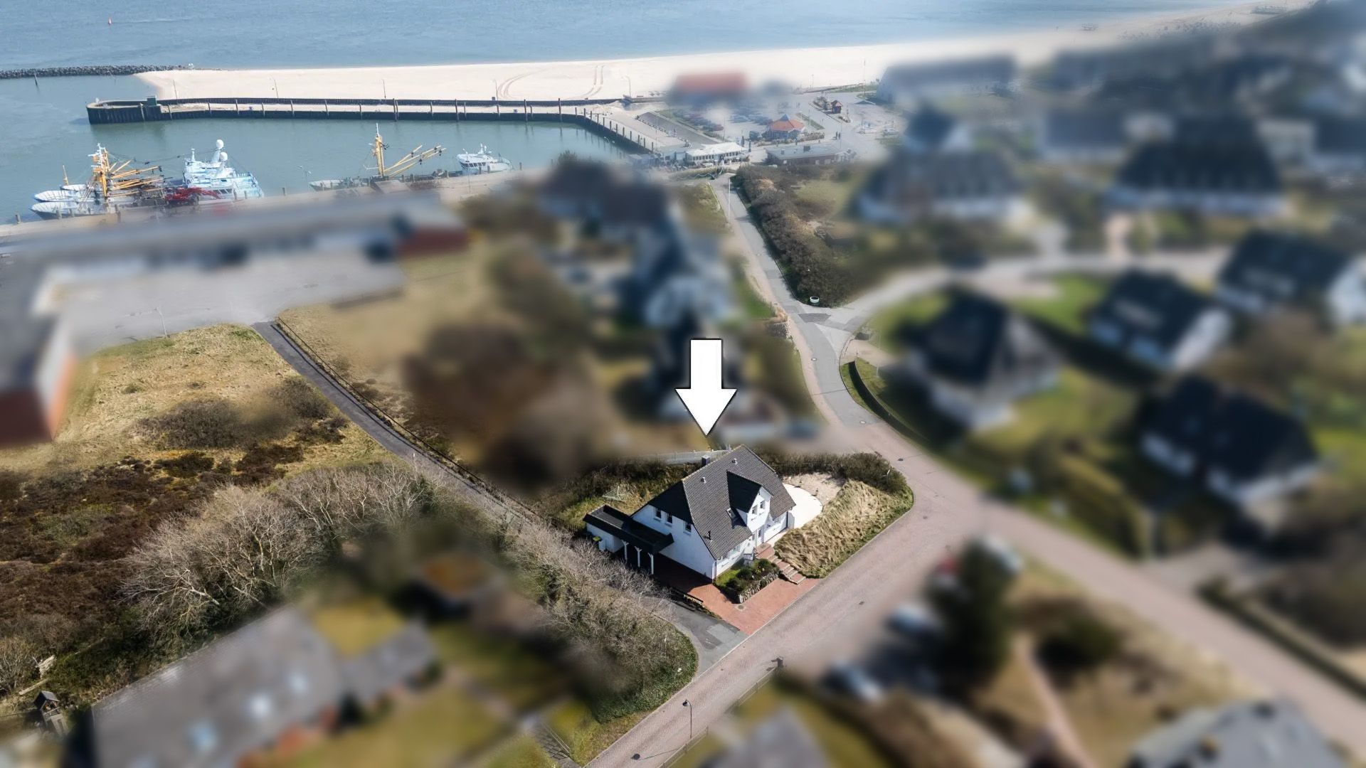 Luftaufnahme eines Hauses mit Pfeil, nahe einer Straße und einem Hafen.