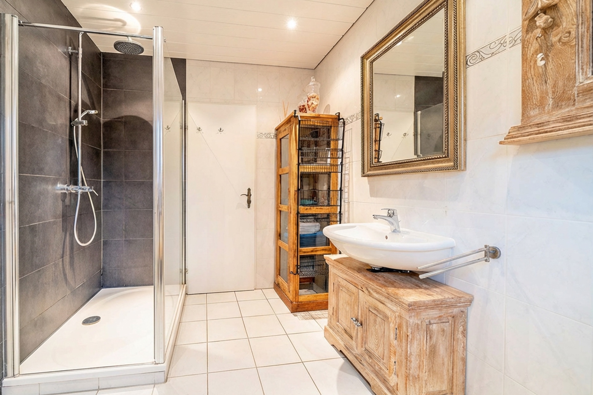 Helles Badezimmer mit Dusche, Waschbecken, Holzschrank und Spiegel.