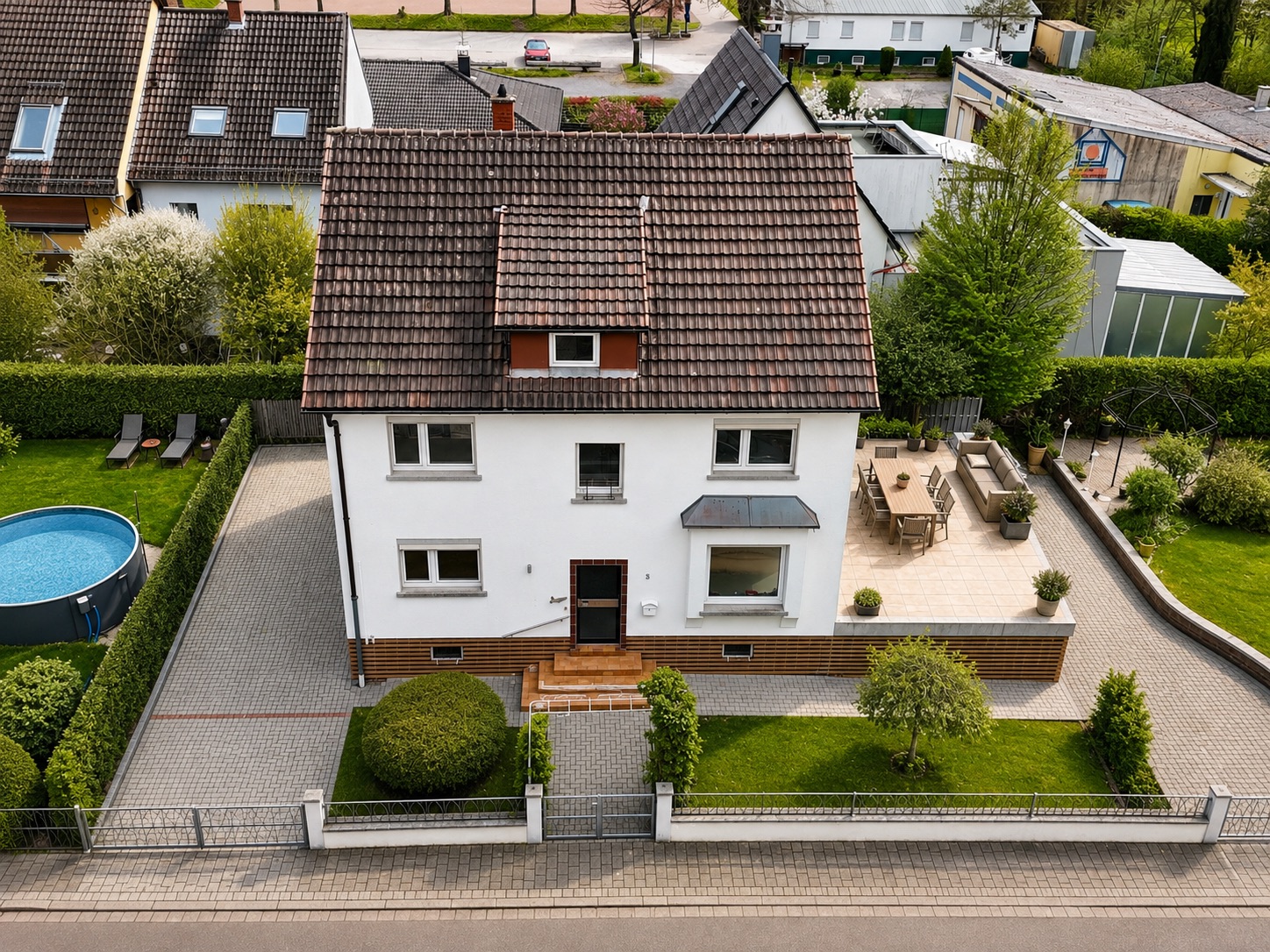 Haus mit rotem Dach, Terrasse, Garten, Pool und Einfahrt, Sicht von oben.