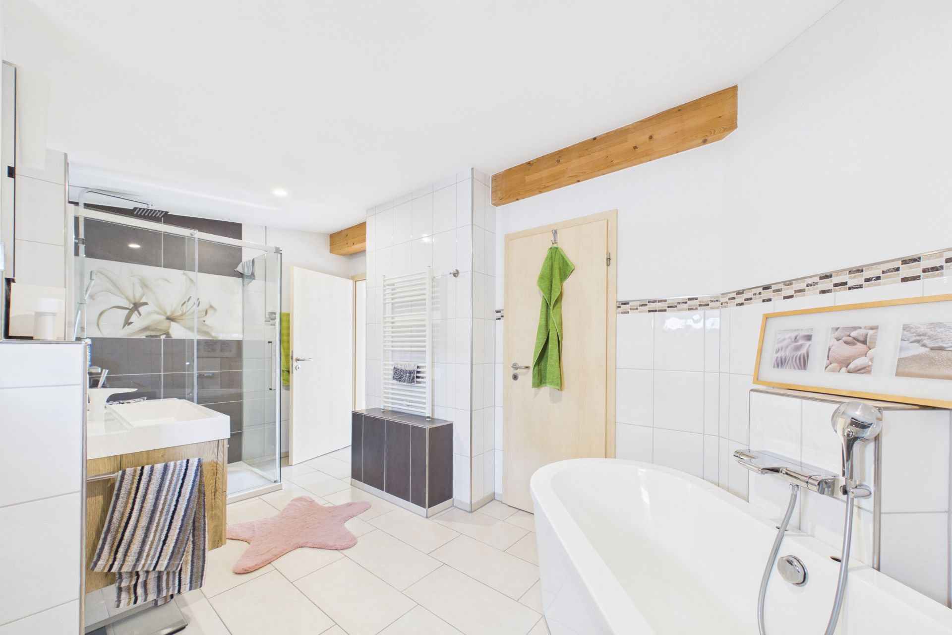 Modernes Badezimmer mit freistehender Badewanne, Dusche, Waschbecken und Dekoration.